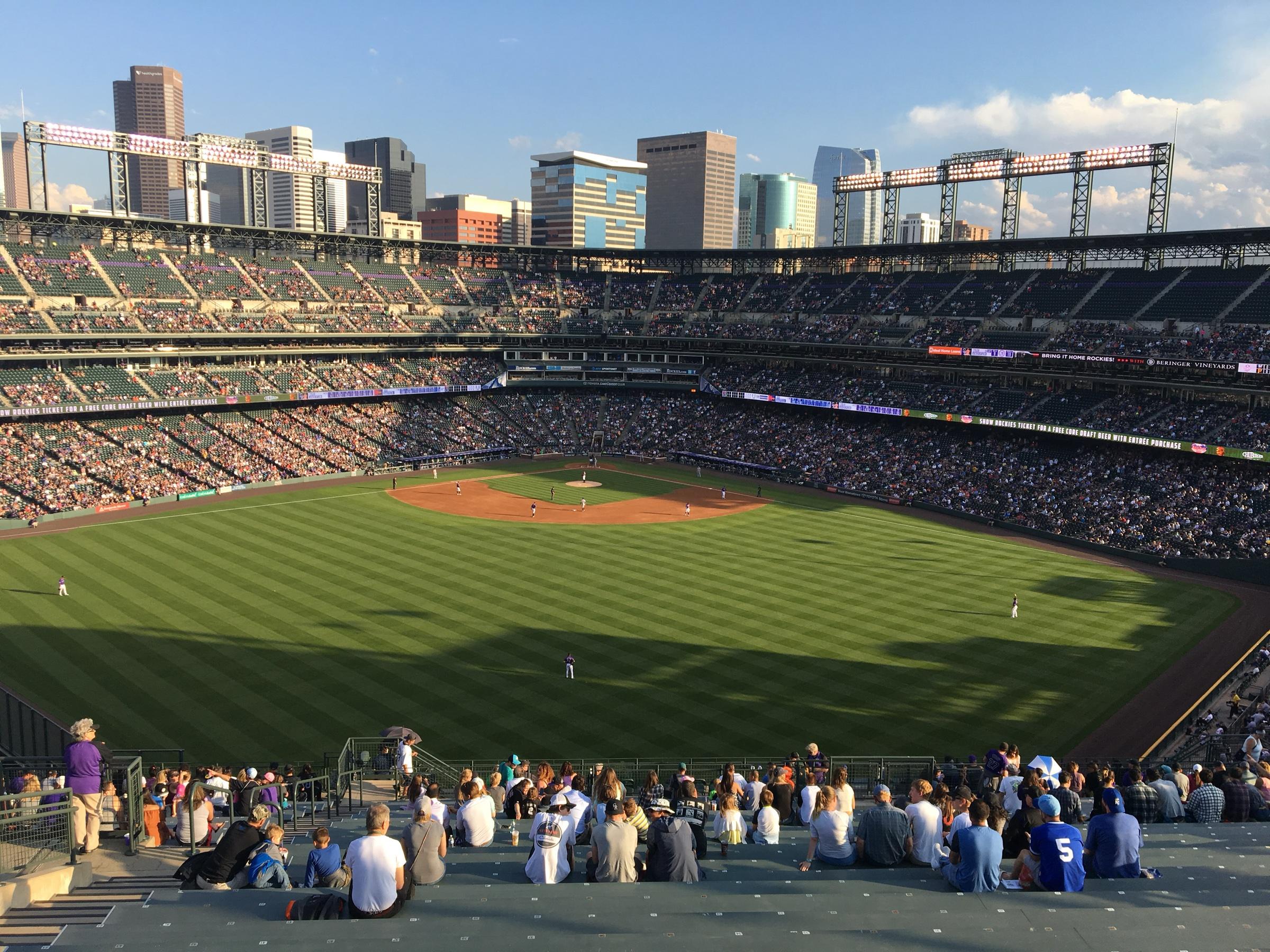 Coors Field from the upper outfield seats, the green diamond below and the Denver skyline beyond