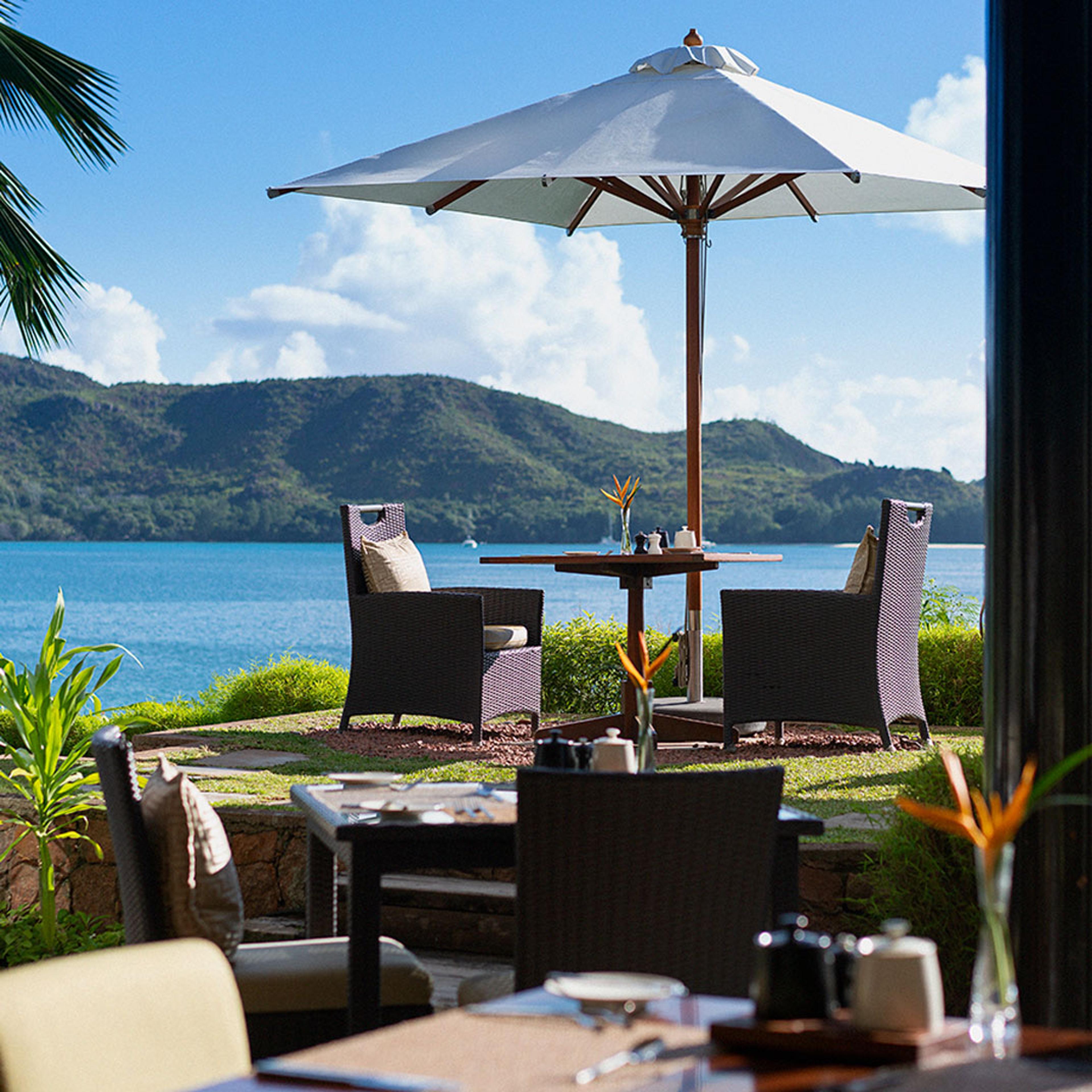 A terrace table above the bay, with islands on the horizon