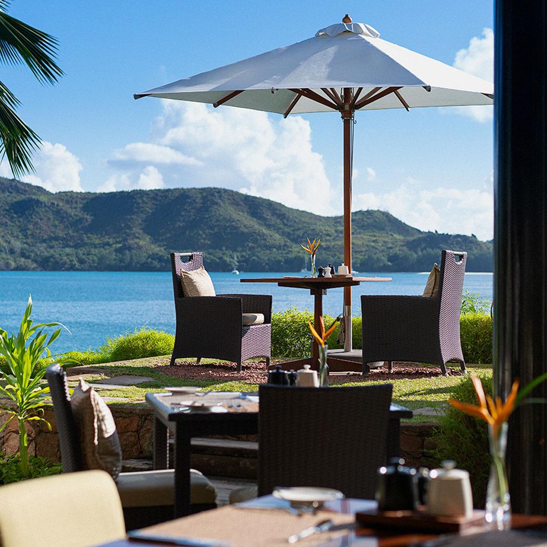 A terrace table above the bay, with islands on the horizon