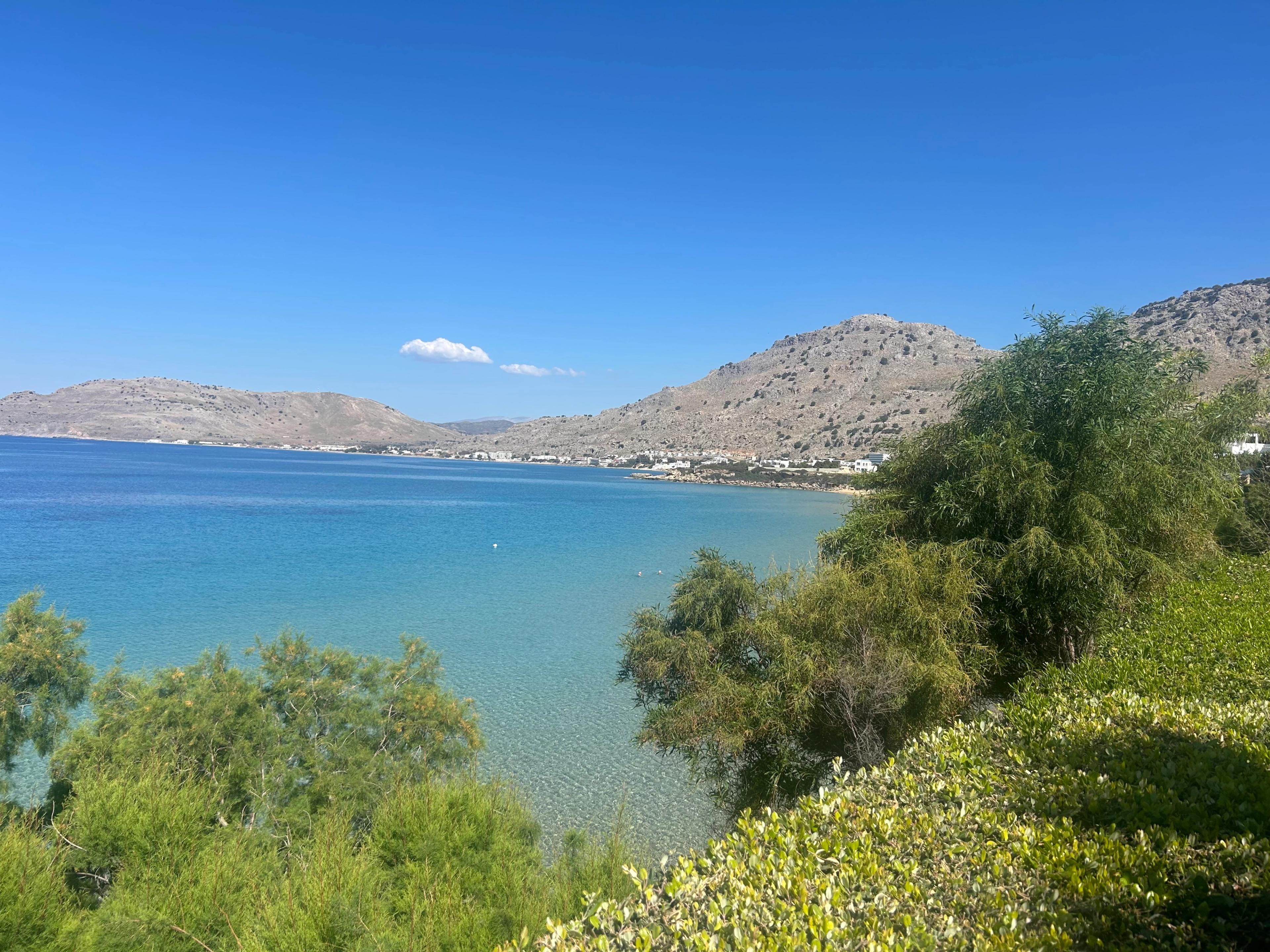 View along the bay from the villa's garden in Pefkos, hills and the town of Lindos in the distance