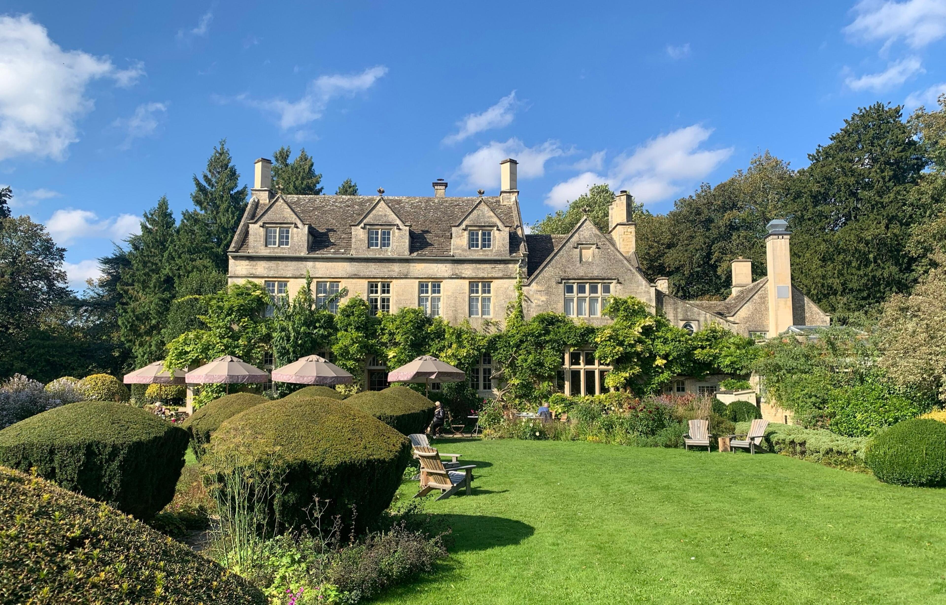Barnsley House, a gabled Cotswold stone manor, above its lawn and clipped yew