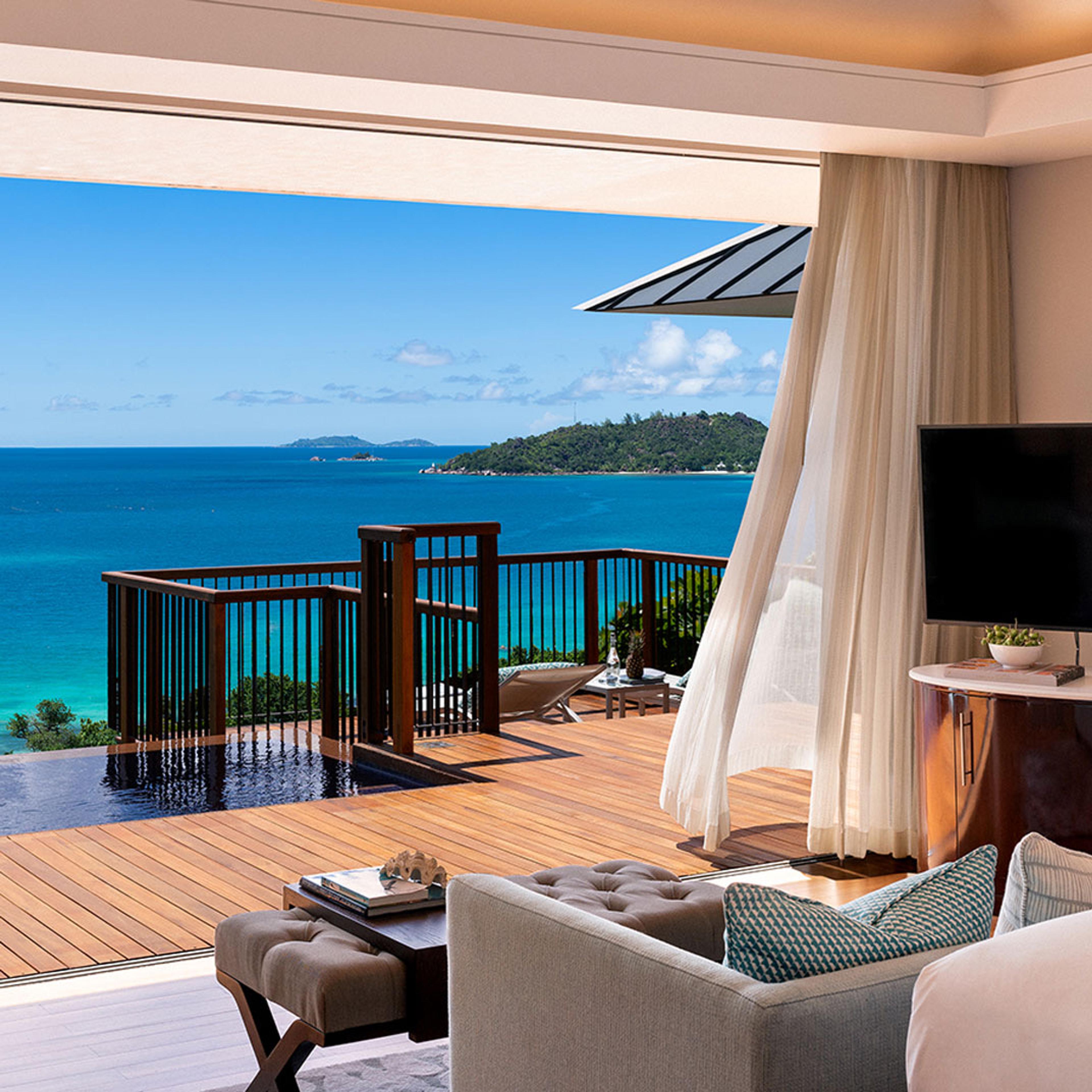 A bedroom opening onto a deck and the sea beyond