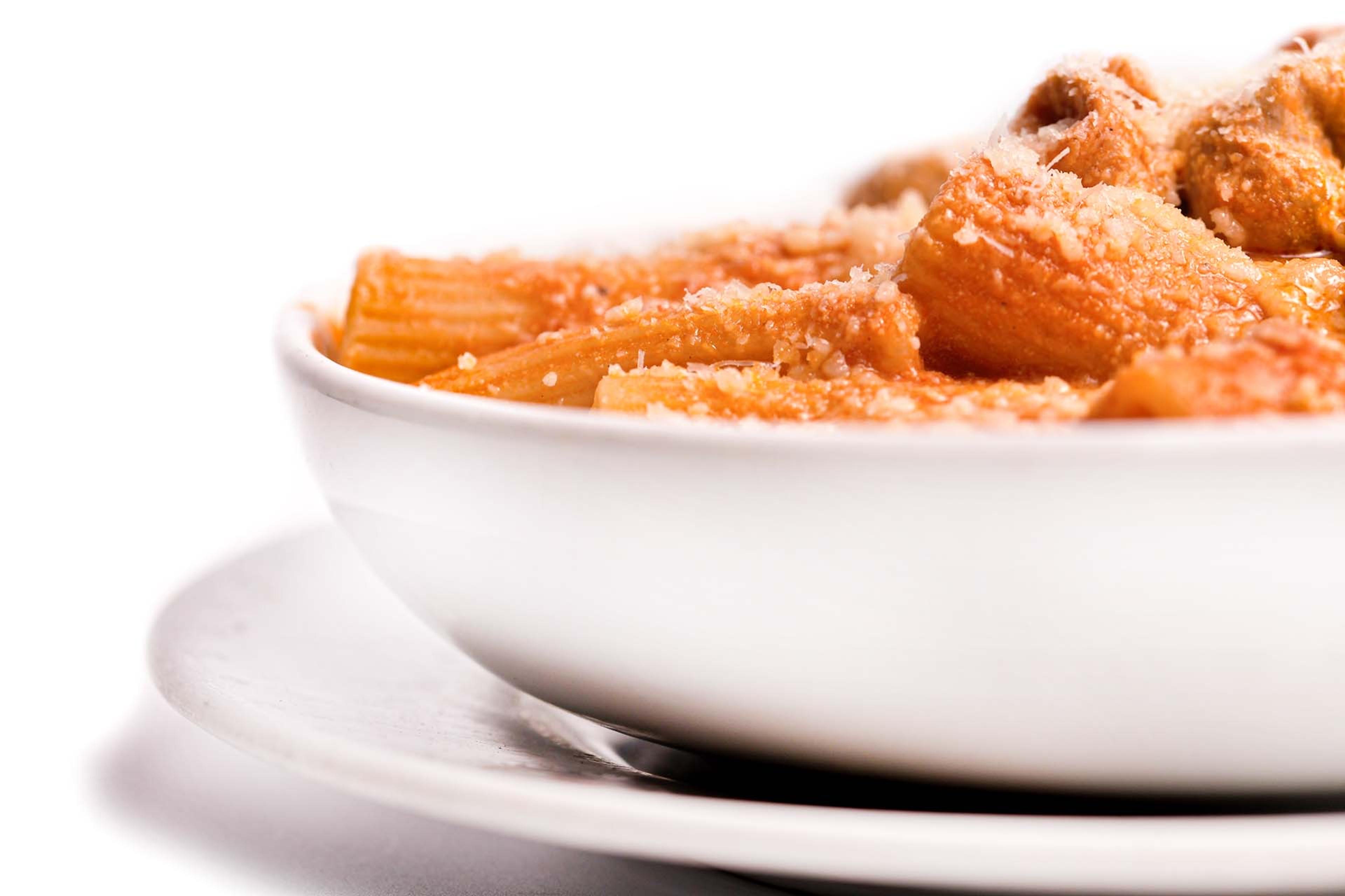 A bowl of rigatoni in tomato sauce under grated pecorino, at Armando al Pantheon