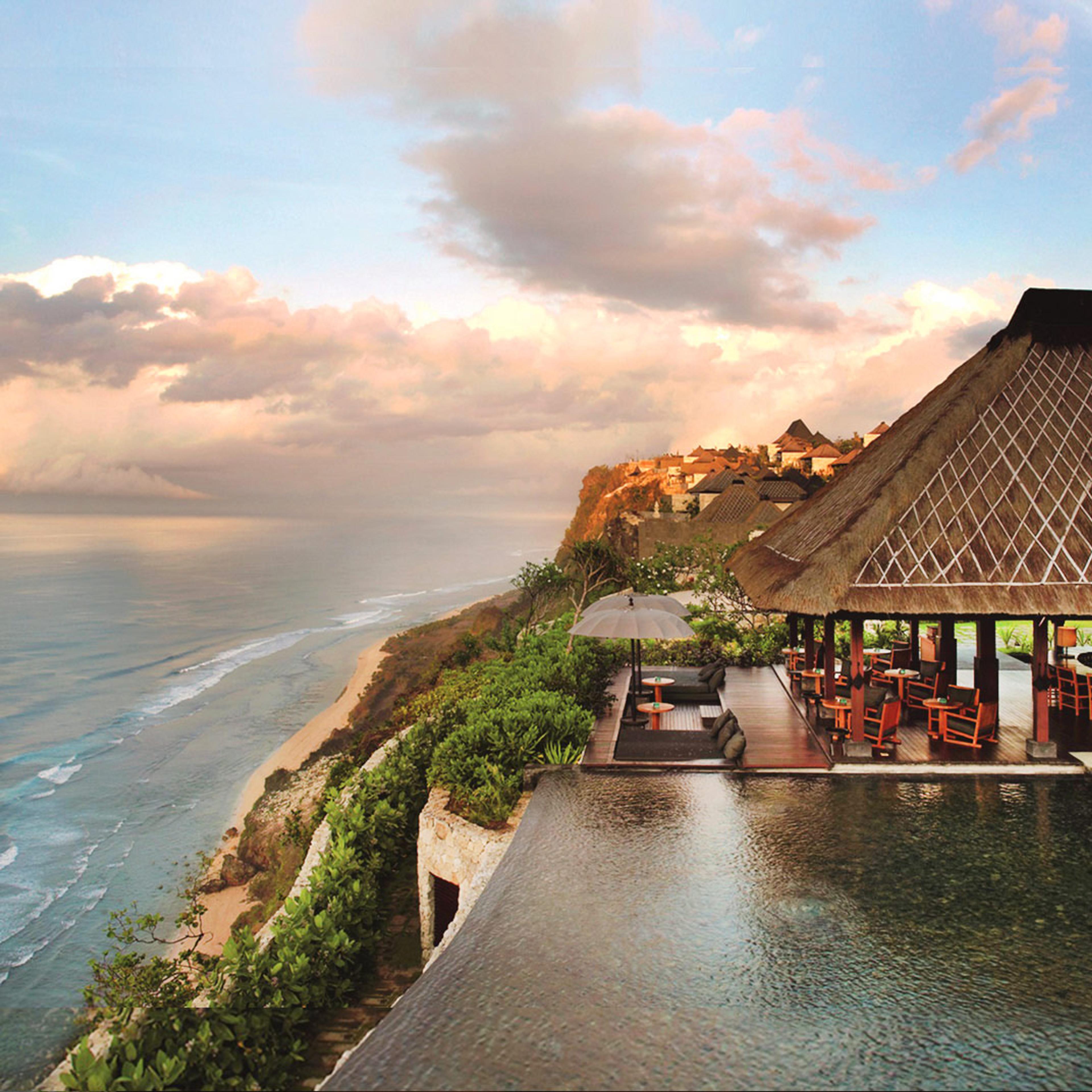 A thatched restaurant pavilion on the cliff edge over the Uluwatu coast and its long beach