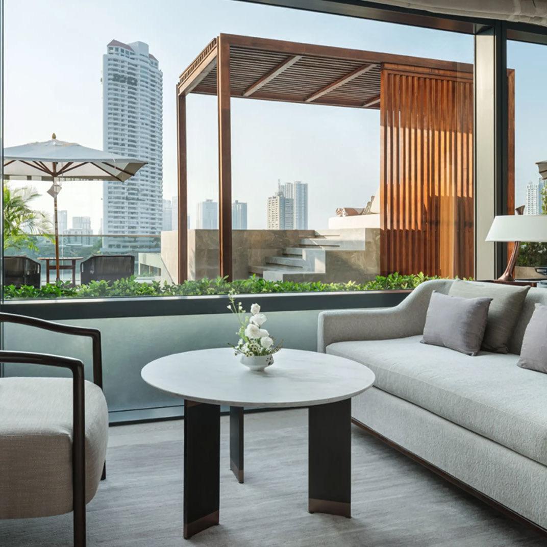 A balcony with lounge chairs looking across the river to the towers