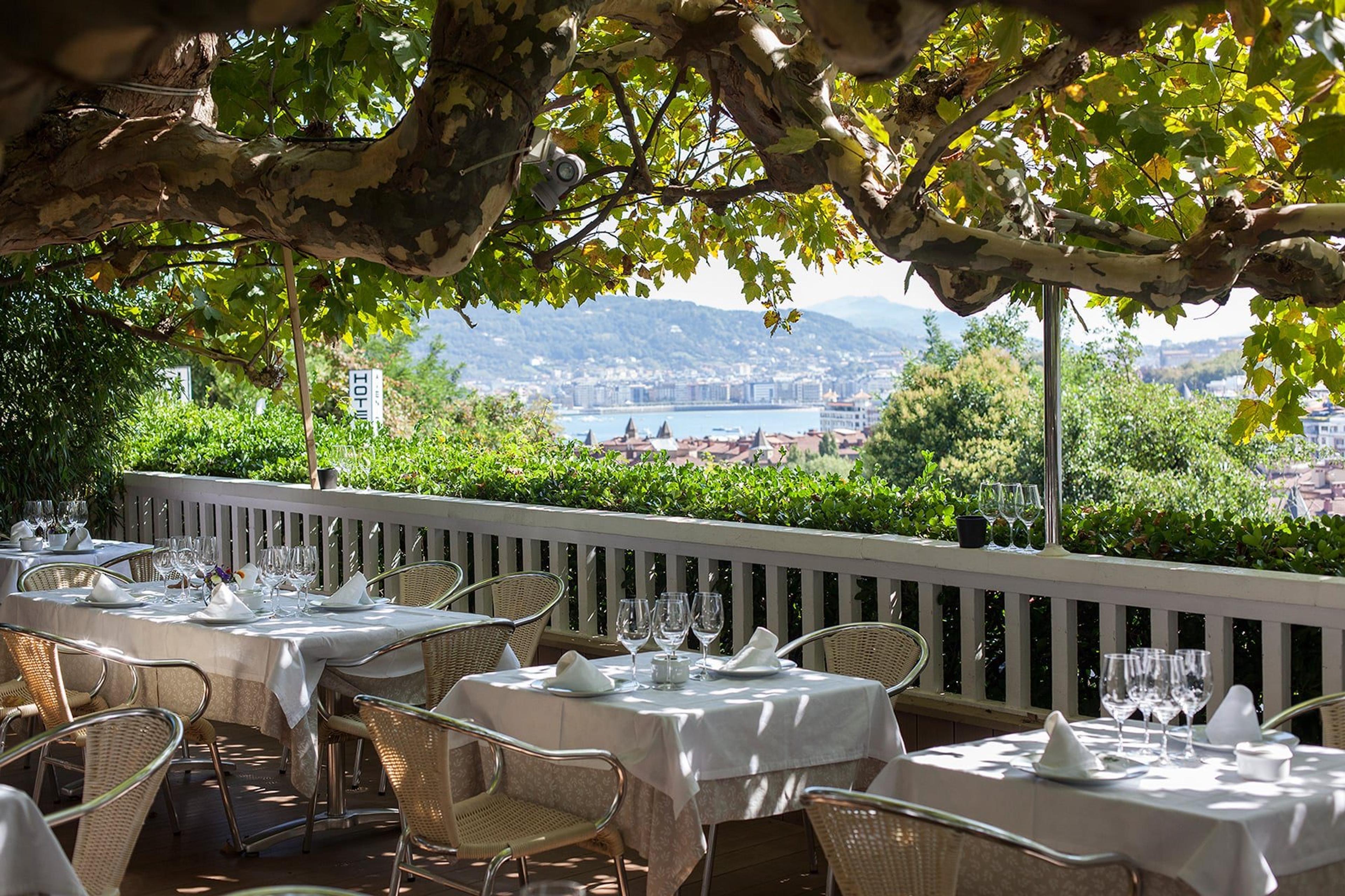 Rekondo's terrace on Monte Igueldo, tables laid under a vine with the bay below