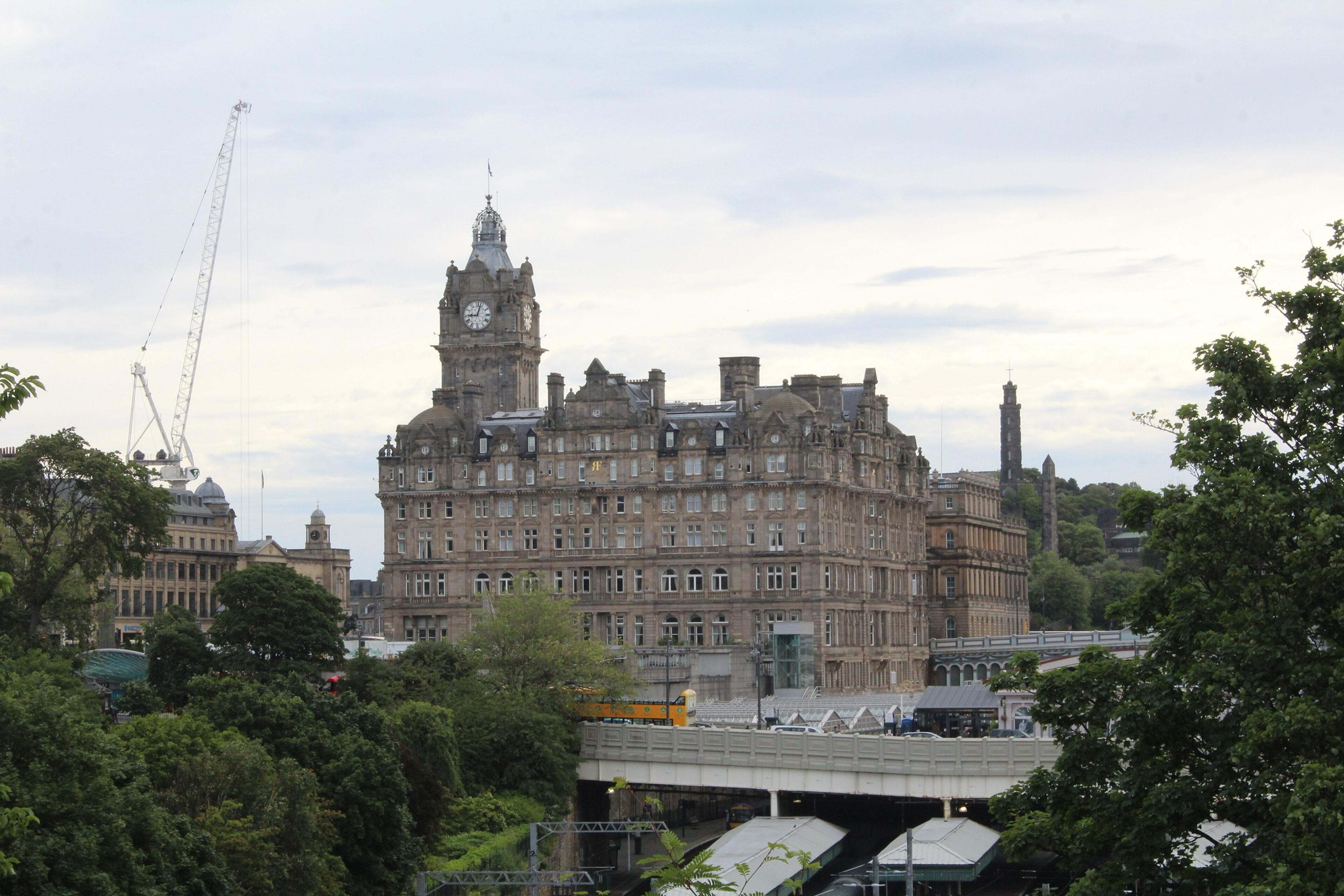 The Balmoral's clock tower rising above the trees and rooftops beside Waverley Station.