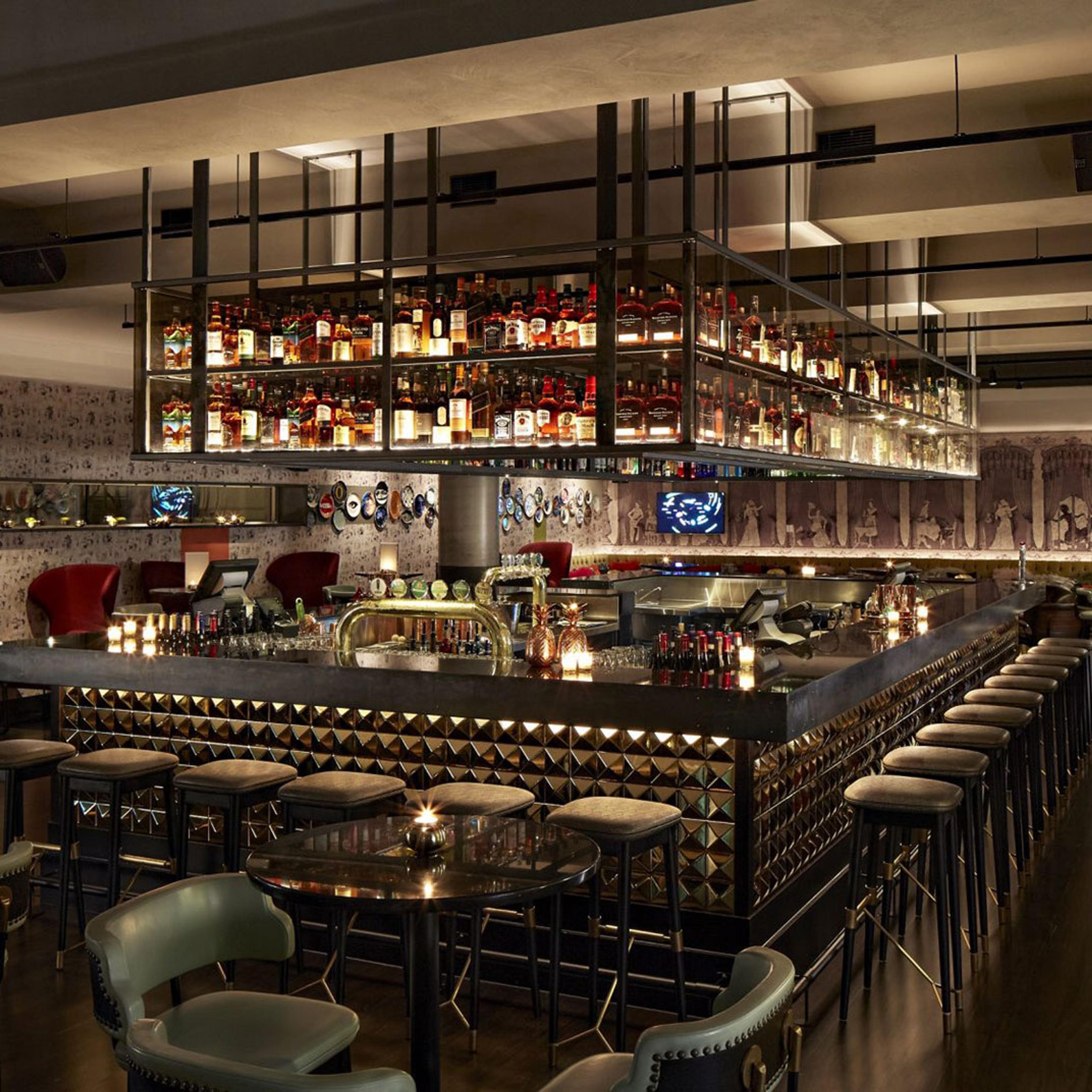 A restaurant with a long bar and shelves of bottles up to the ceiling
