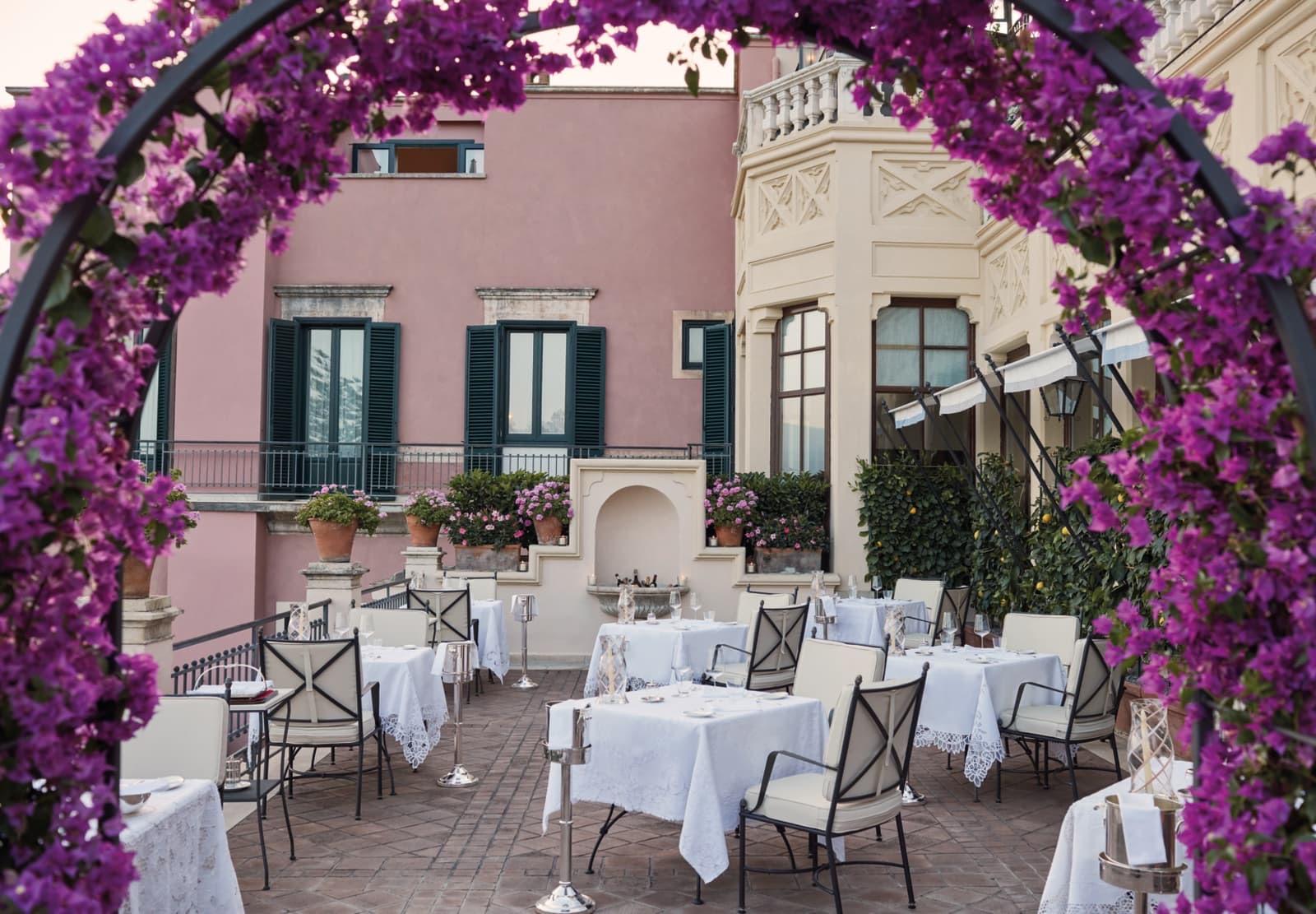 Otto Geleng's terrace in Taormina, tables laid under an arch of purple bougainvillea