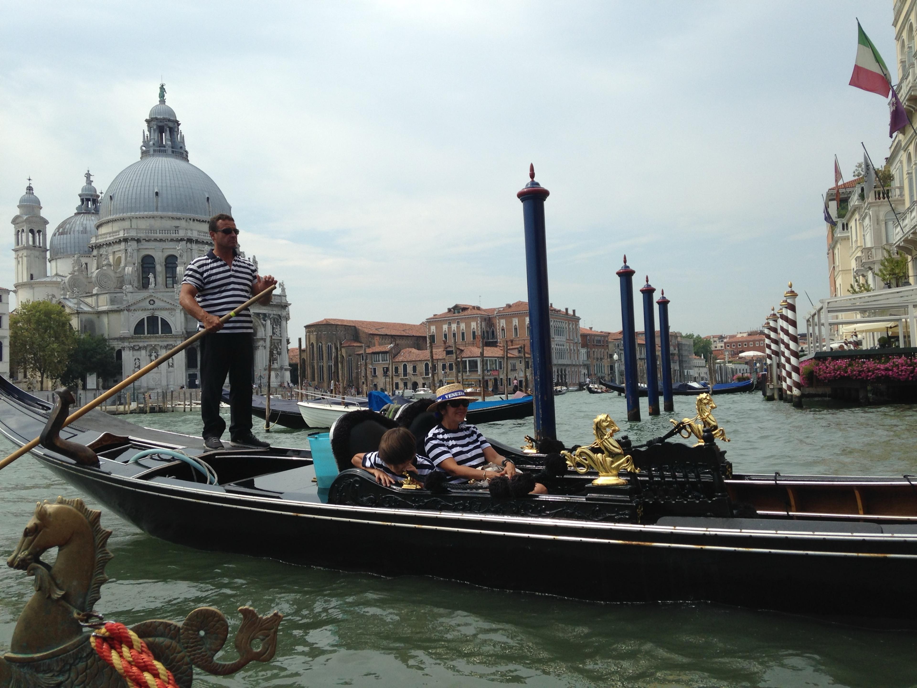 A gondolier rowing past the dome of Santa Maria della Salute at the mouth of the Grand Canal