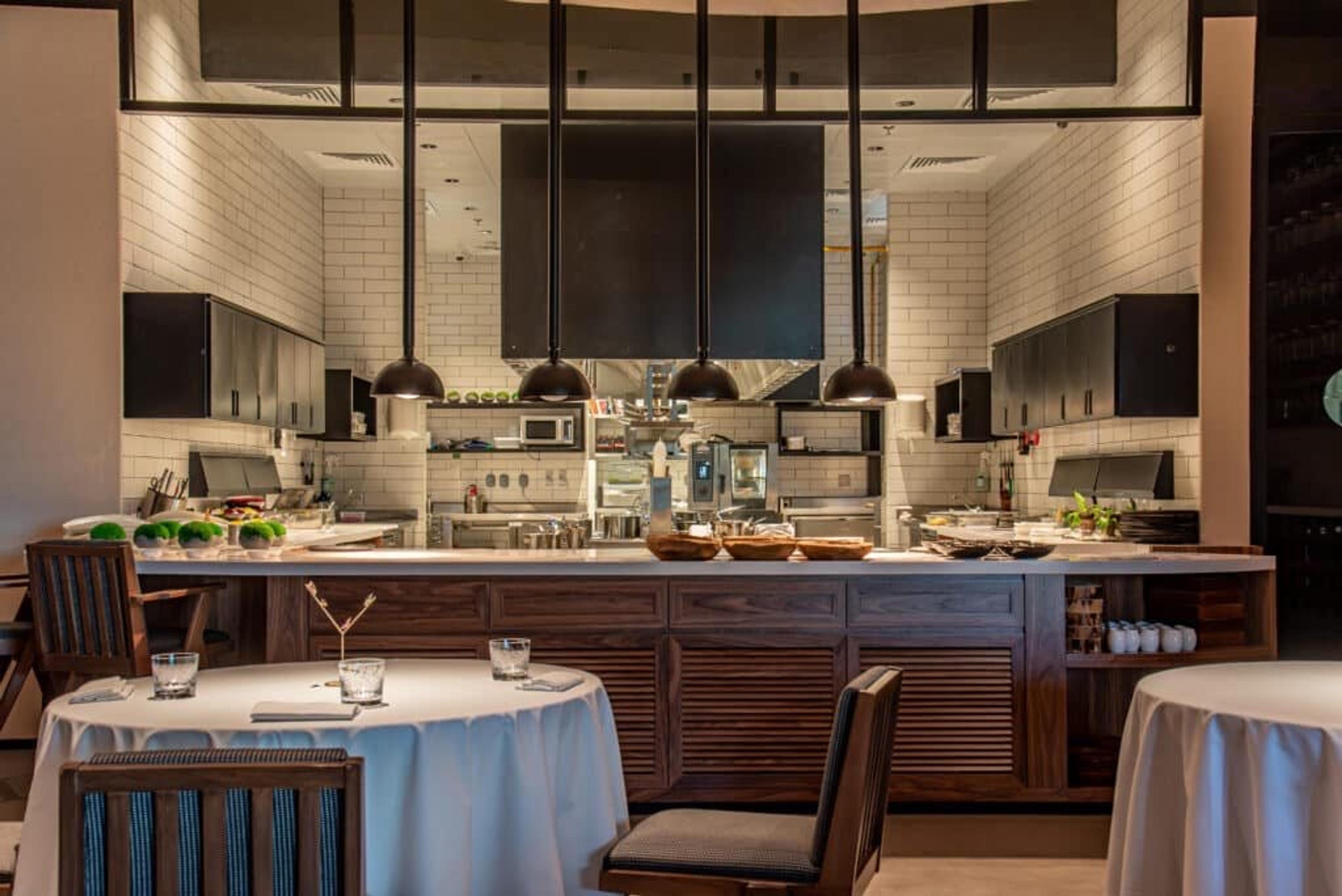 The dining room at Trèsind Studio, tables facing the open kitchen