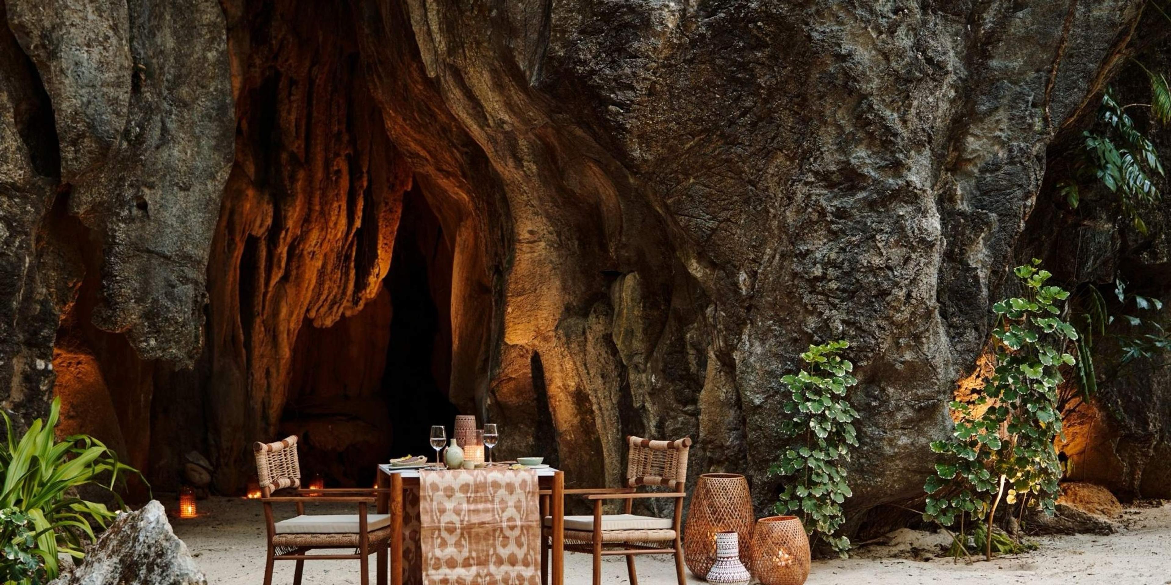 A table laid for dinner inside a lantern-lit limestone cave.