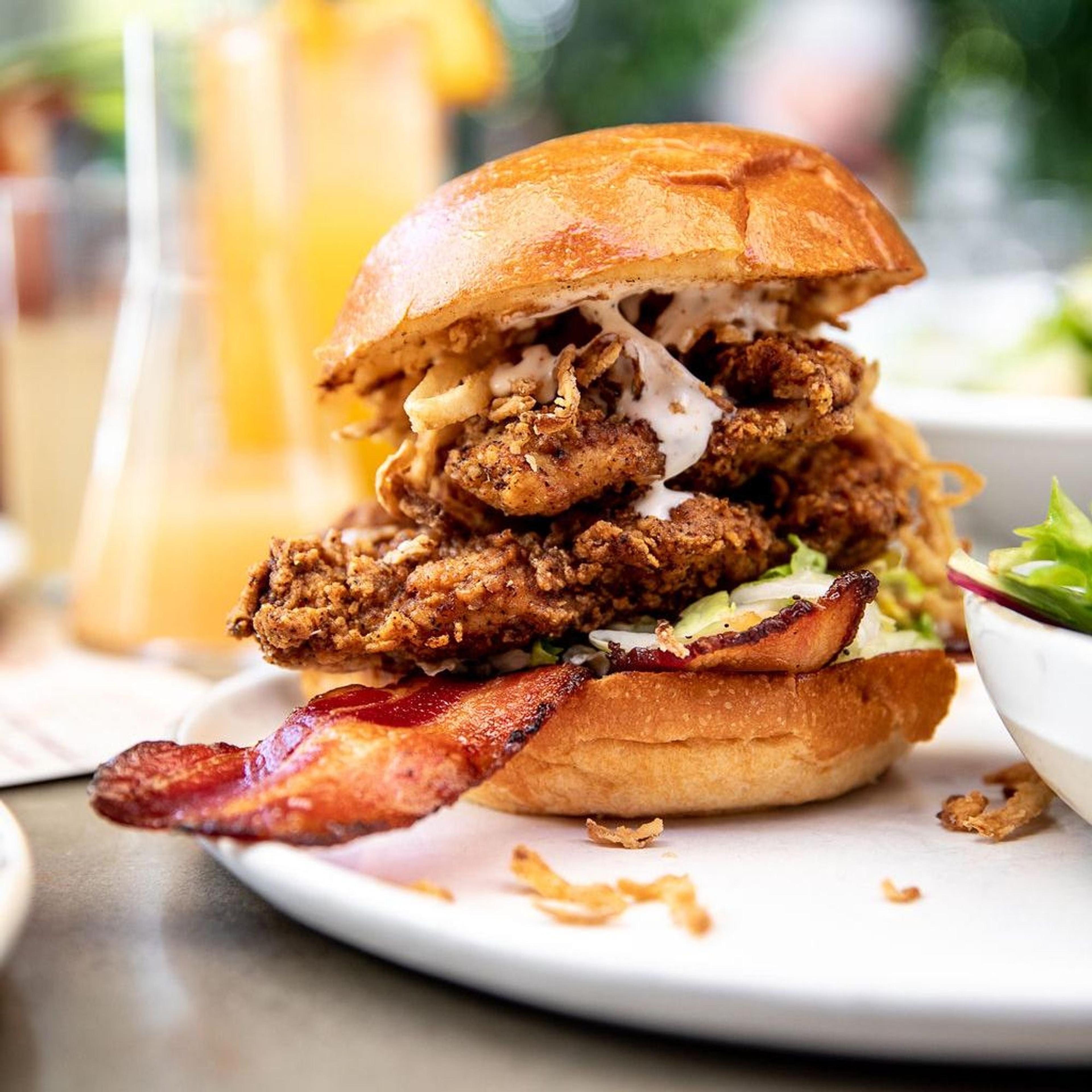 A fried chicken sandwich stacked with bacon