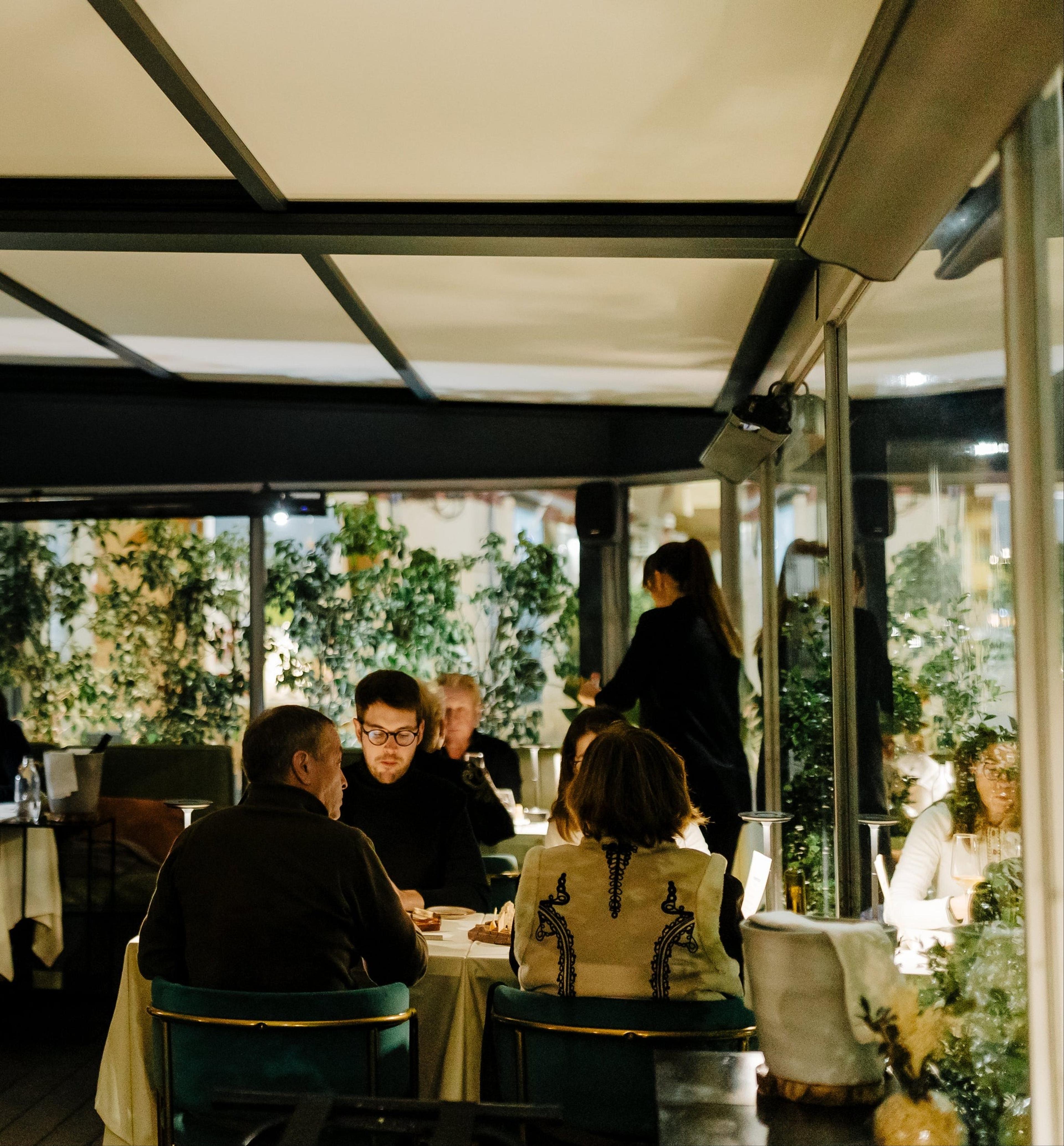 Diners at Alameda in Faro, in a room of plants and glass