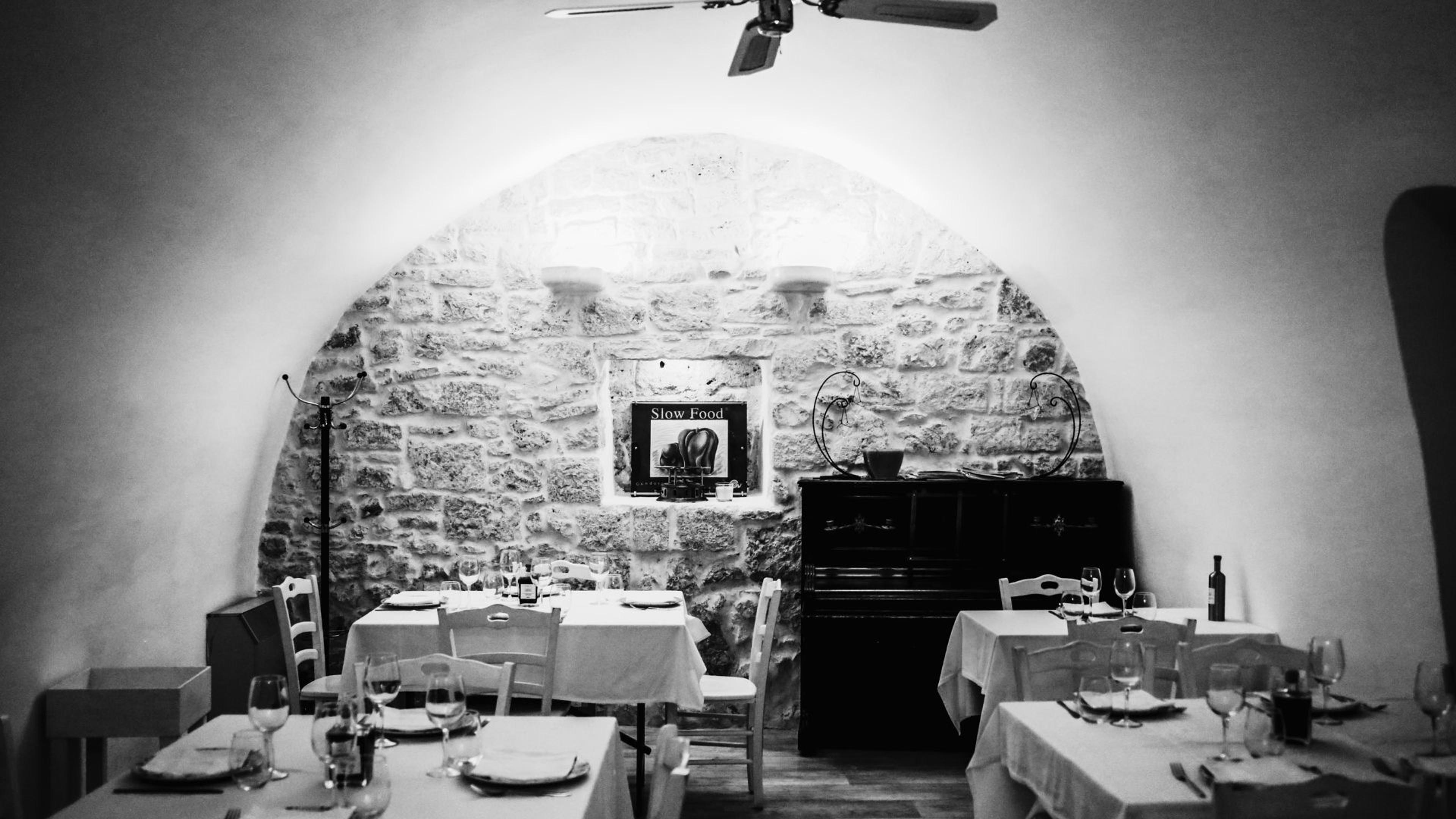 Cibus's vaulted stone dining room in black and white, tables laid with white cloths