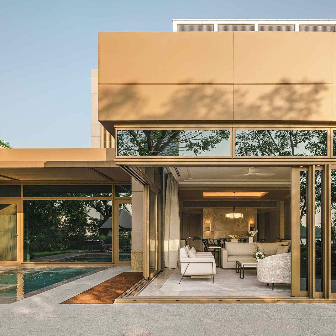 A villa opening through glass doors onto its own pool