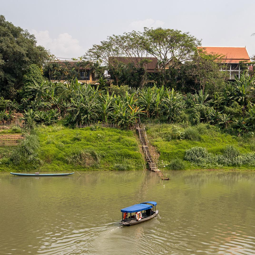The river below a wooded bank, with a boat moored