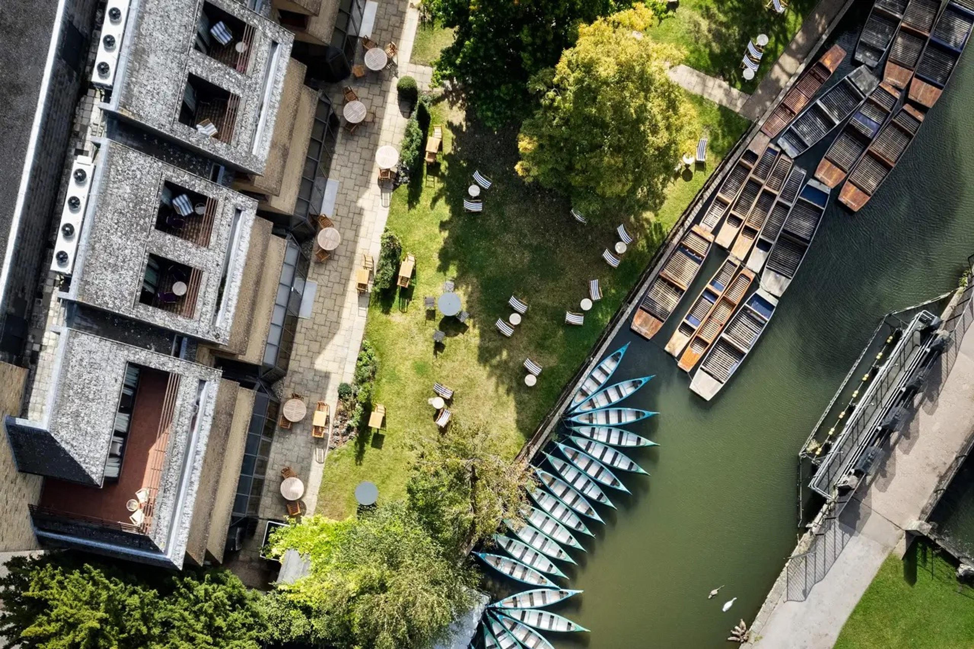 The hotel seen from above beside the river, with a row of punts moored at the Mill Pond