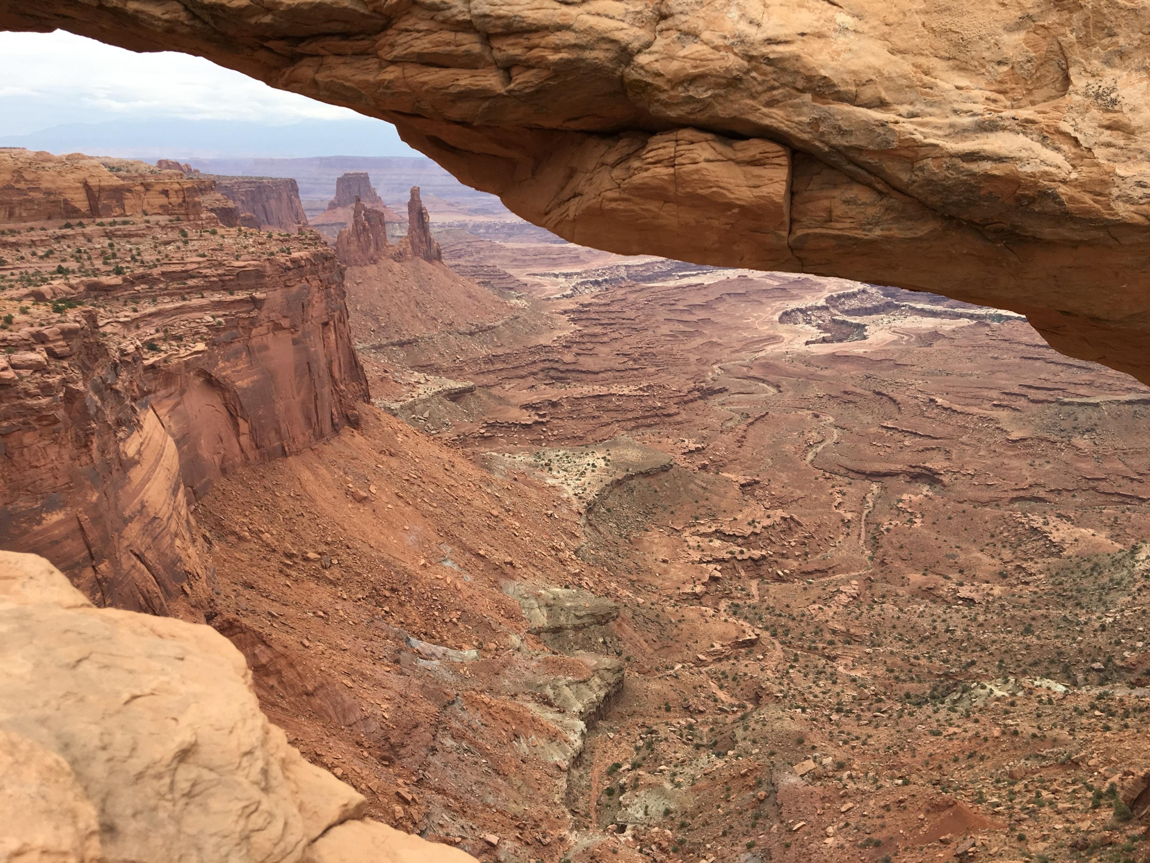 Mesa Arch framing a view across red canyons and rock towers