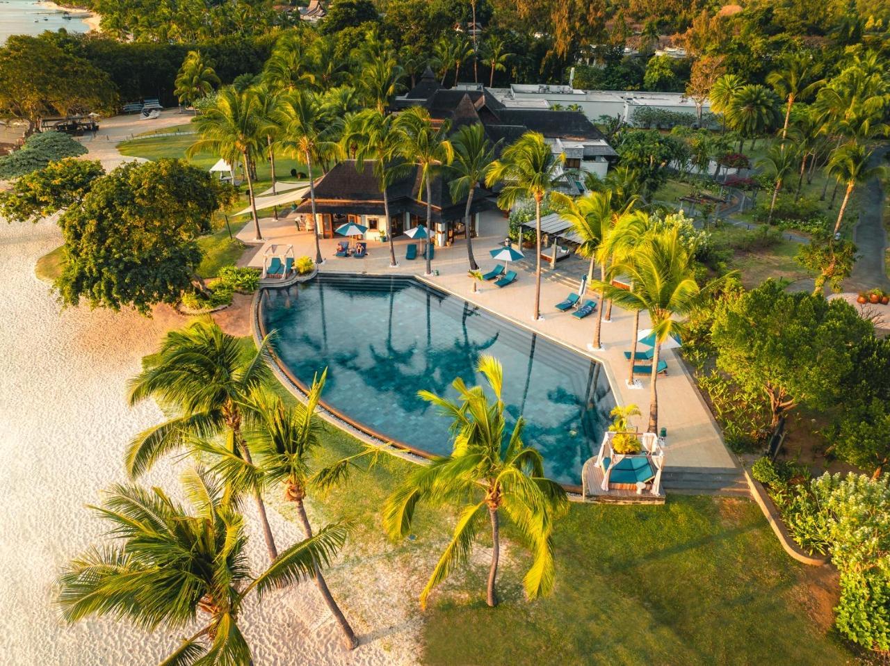The resort from above, a pool among palms by the sea