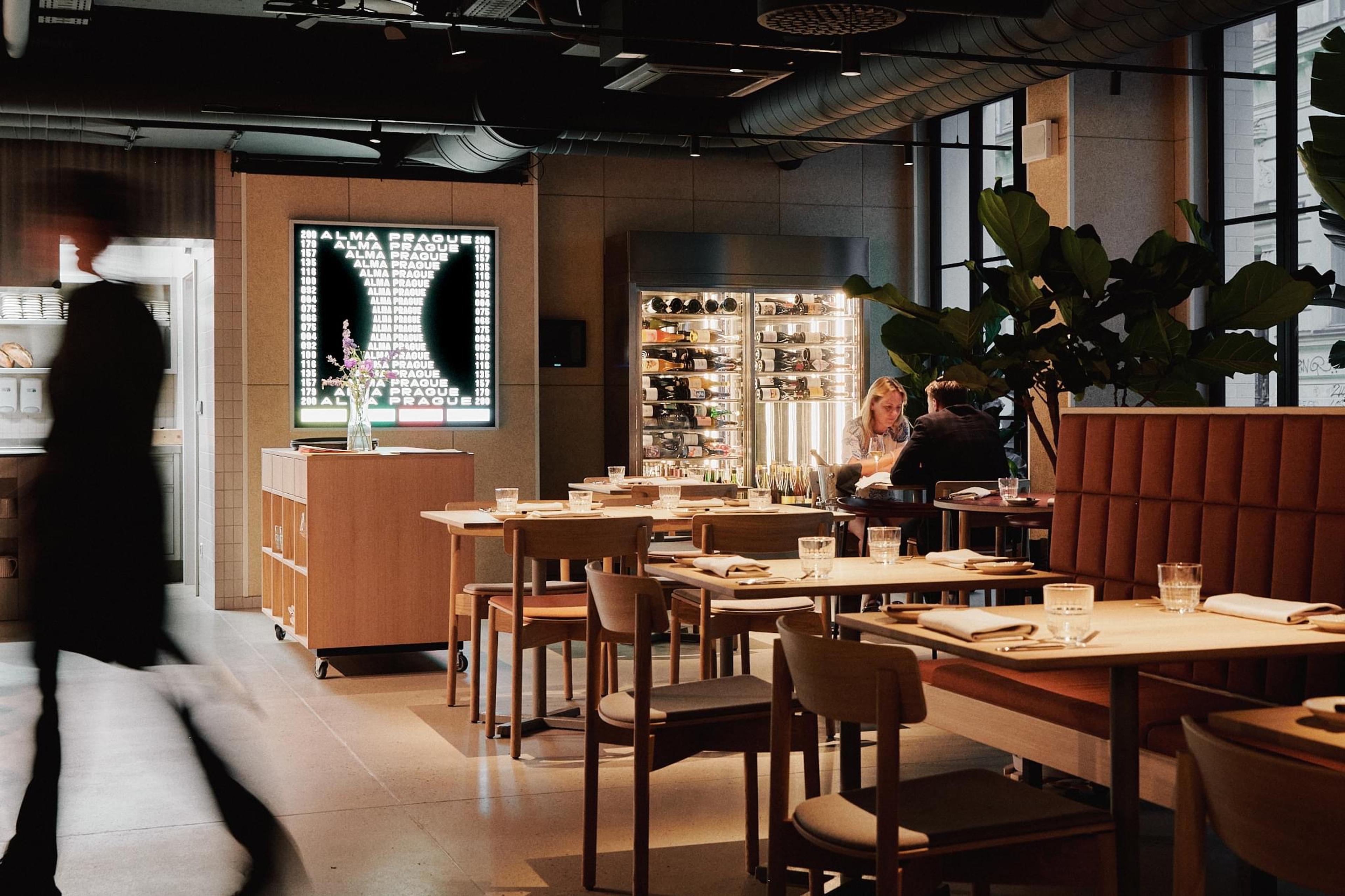 Wooden tables and chairs in a high-ceilinged dining room