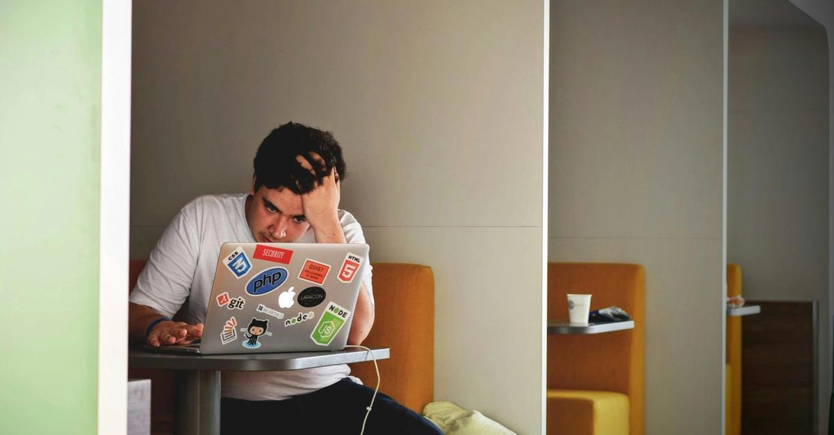 Man stressed on macbook pro.