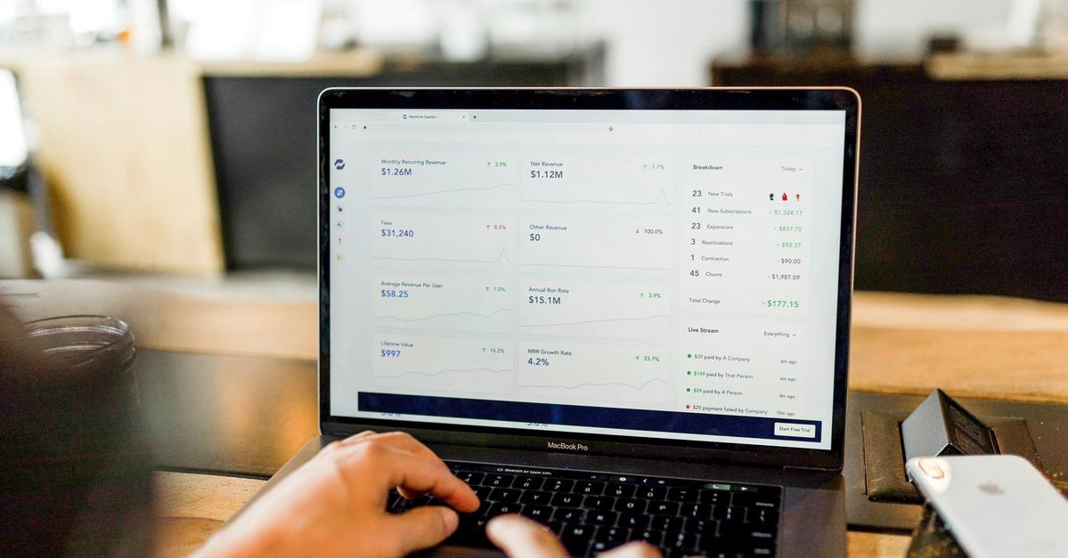 Many using a macbook pro on his desk.