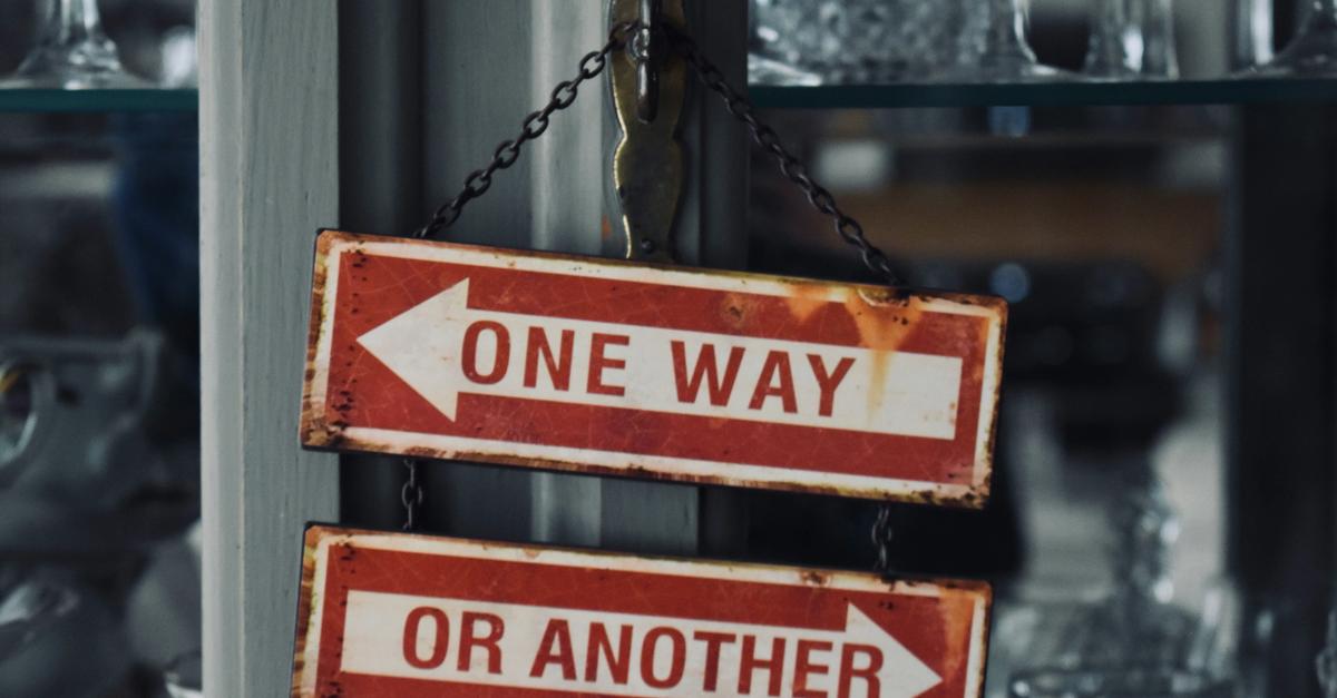 Two red arrow signs saying one way (pointing to the left) or another (pointing to the right).