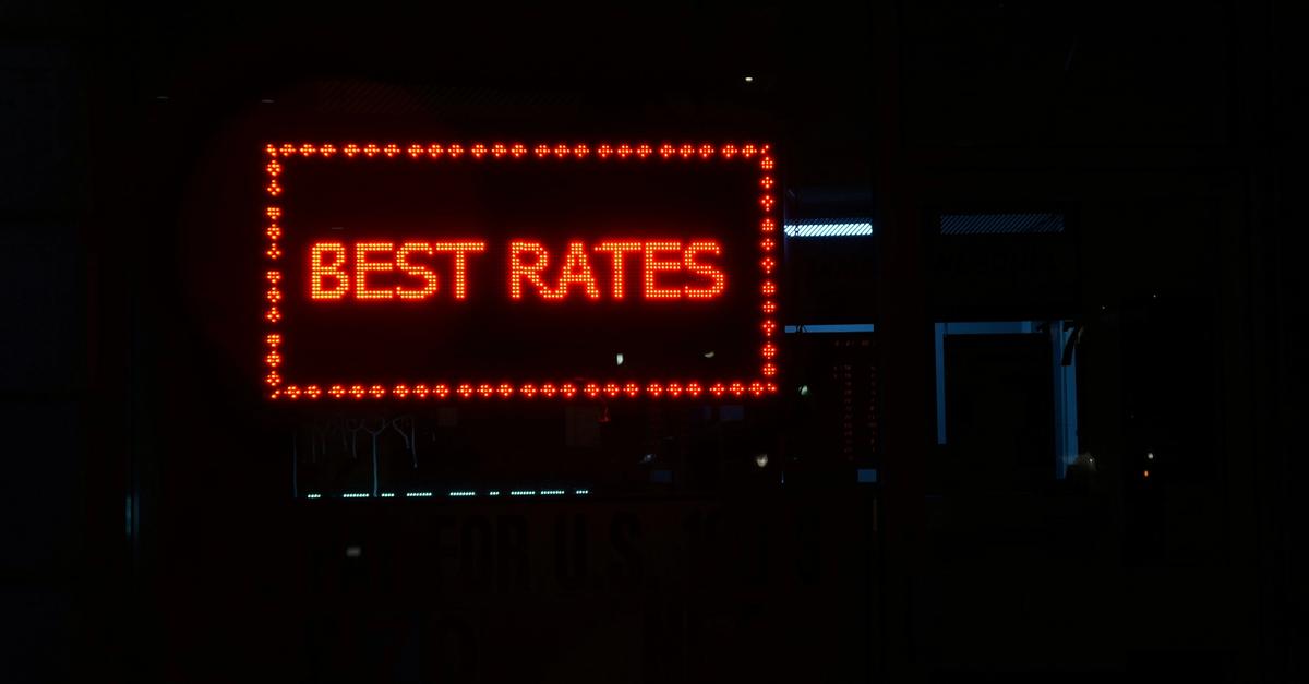Orange neon sign that says best rates in a dark setting.