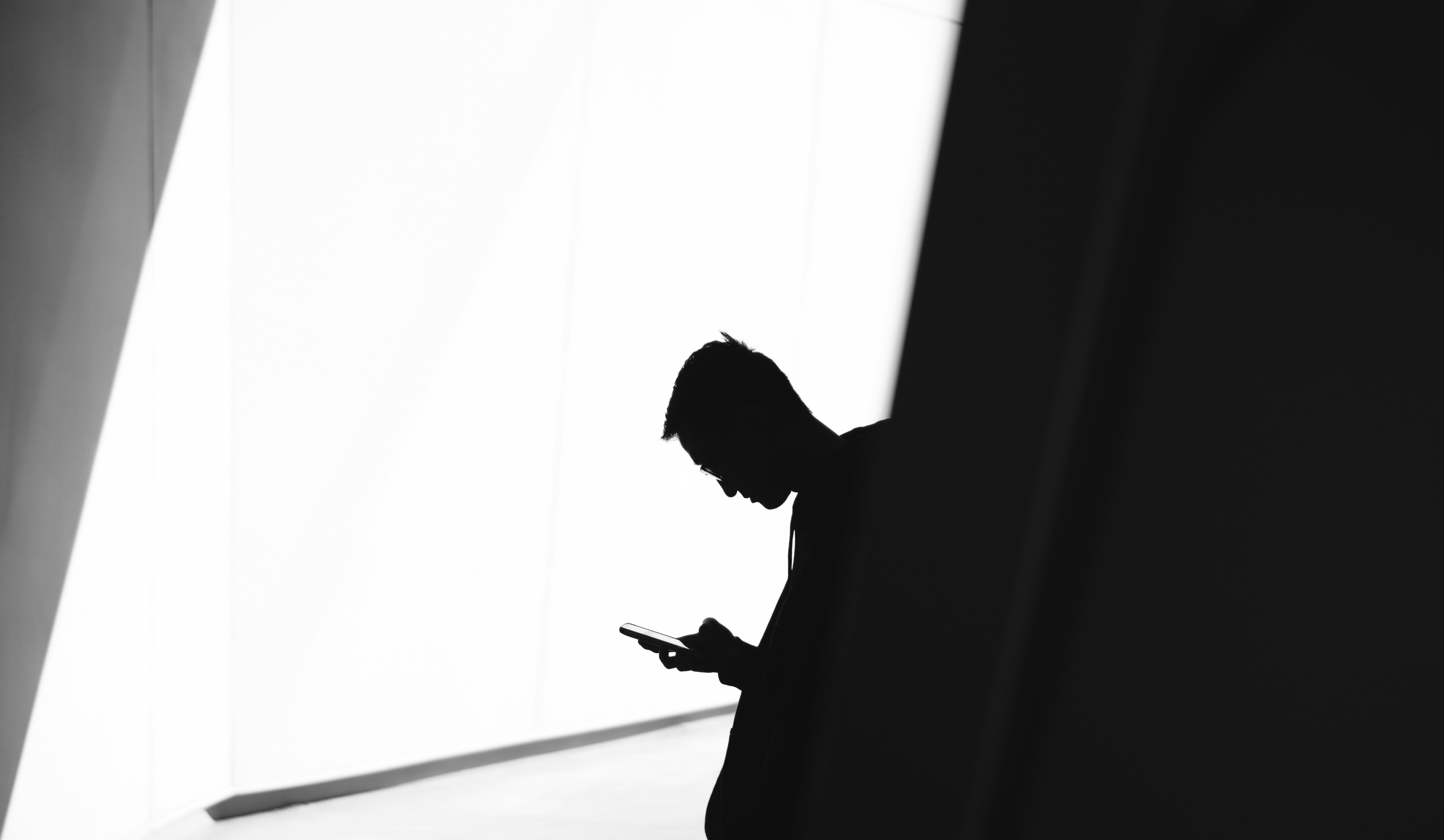 Man looking at his phone in black and white by Warren.