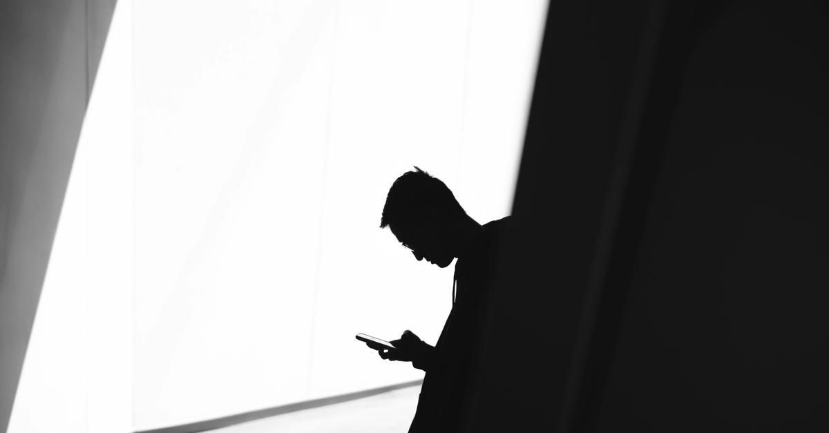 Man looking at his phone in black and white by Warren.