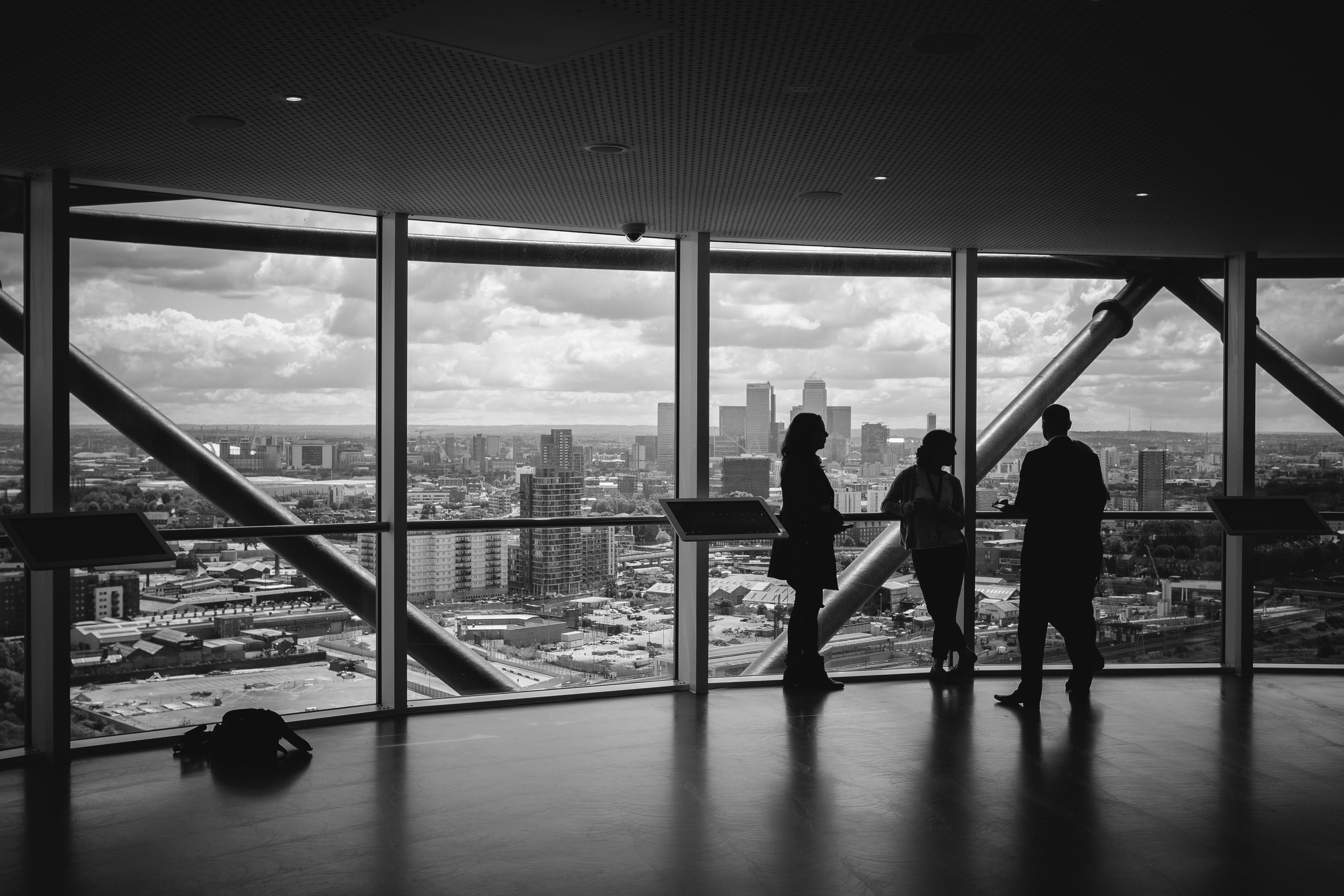 Three individuals looking over view of a city in the background.