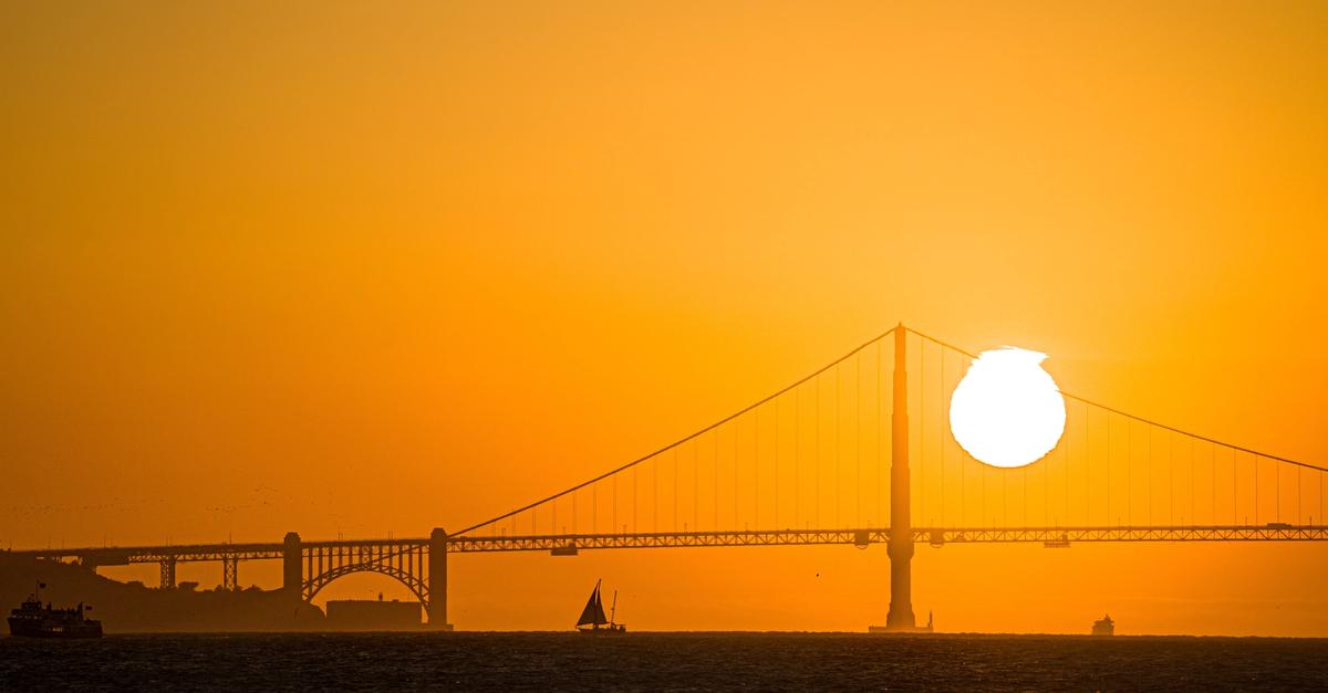 View of an orange sunset near a bridge.