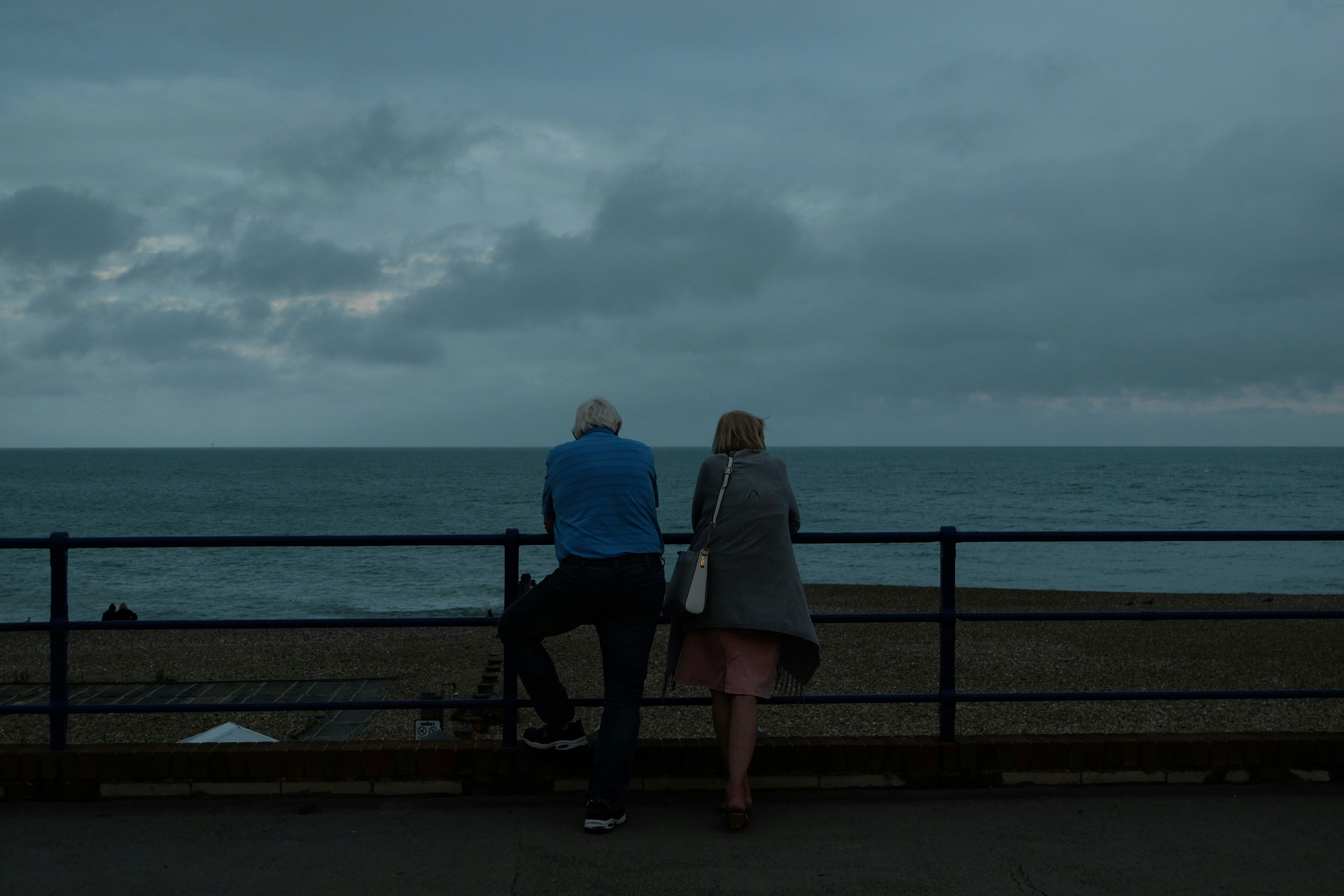 Couple on beach pier contemplating divorce by Al Elmes.