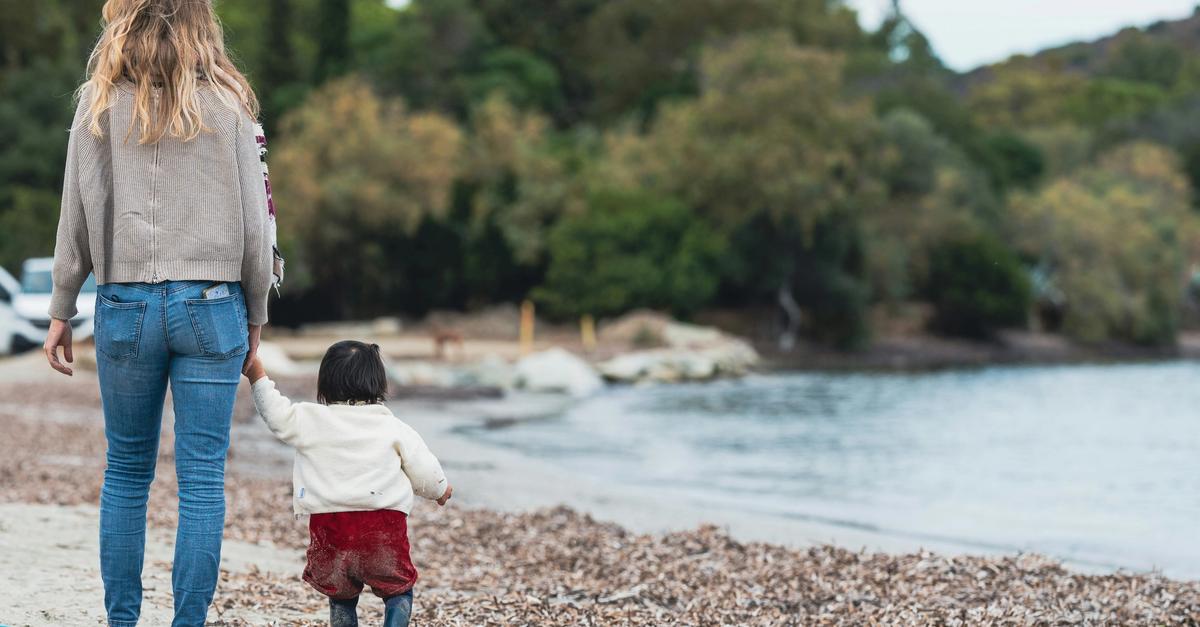 Mother and child walking on the beach by guillaume de germaine.