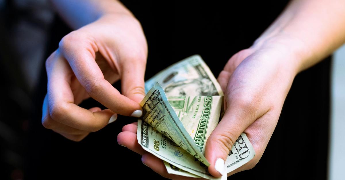 Woman counting money by Igal Ness.