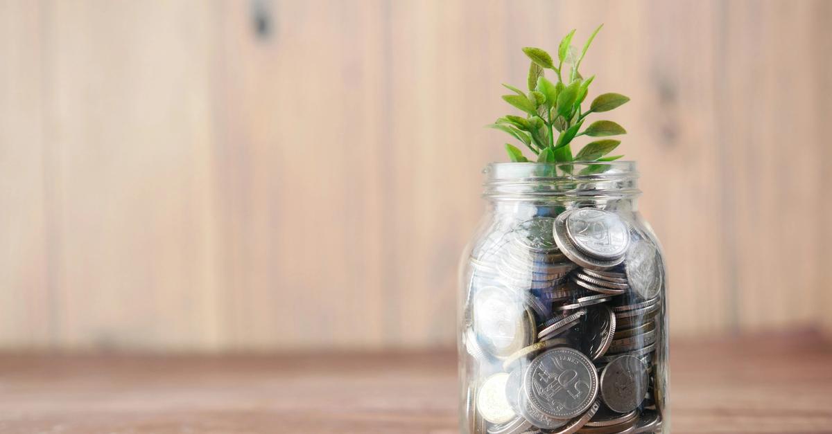 Savings jar with change in a plant growing from it.
