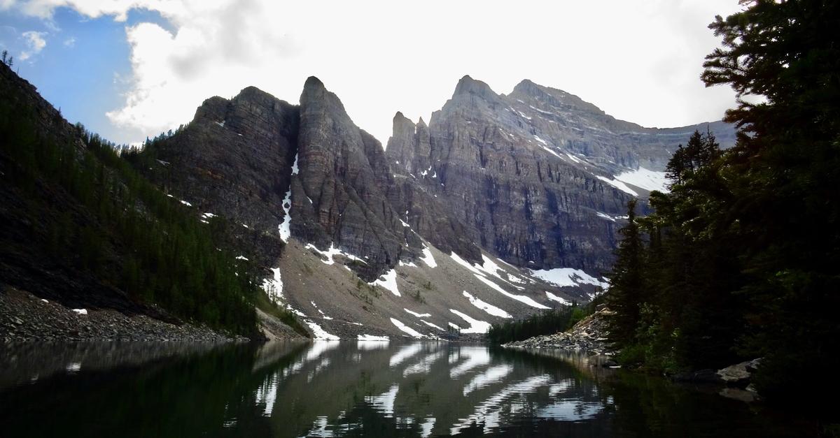 Reflective water in between snowy mountain pass.