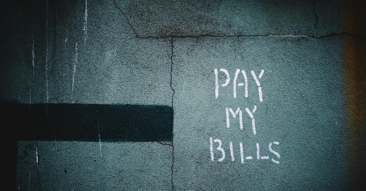 A concrete wall with "Pay My Bills" posted on it by Hiroshi Kimura.
