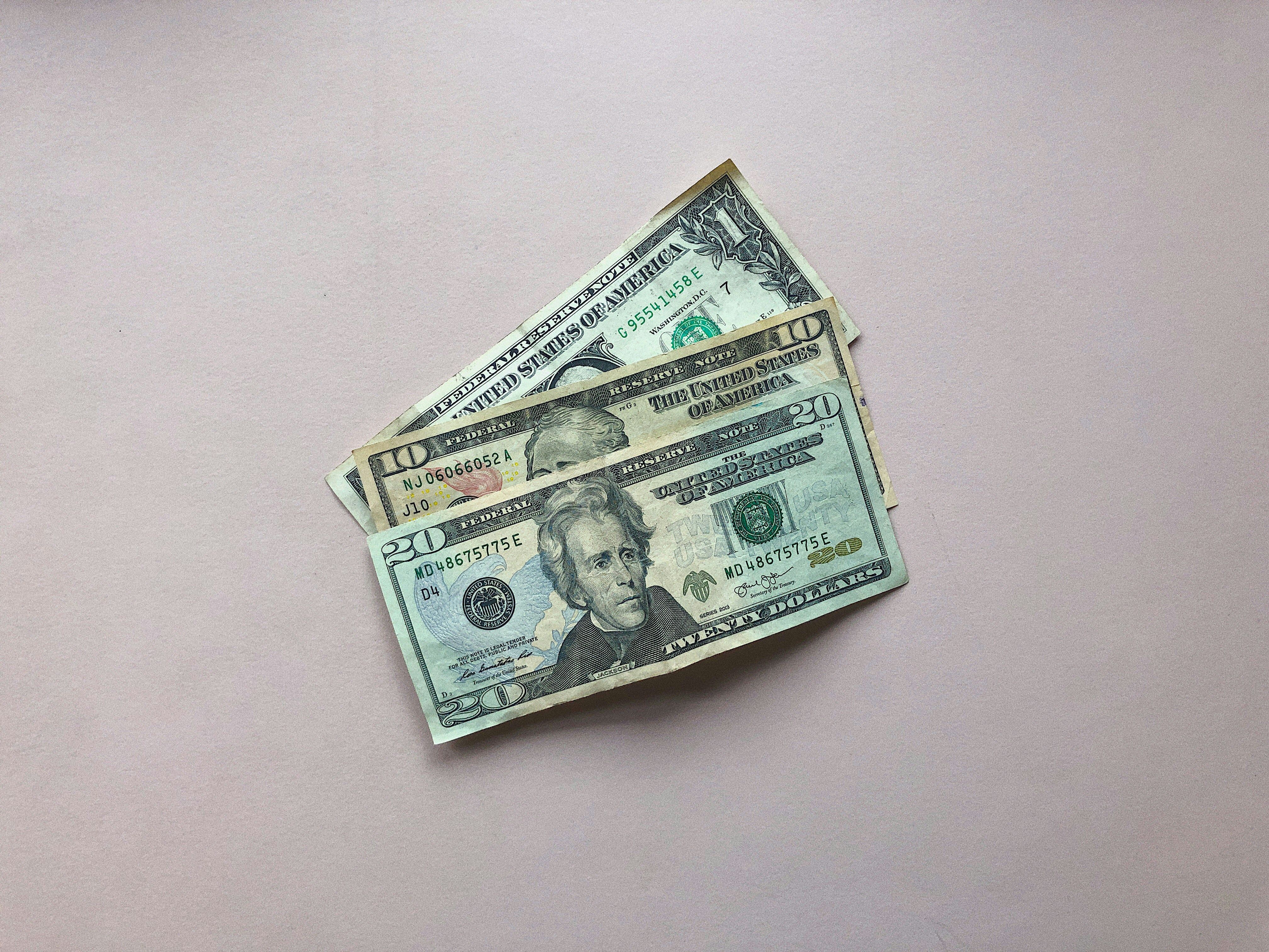 A $20 bill, a $10 bill and a $1 bill by Ryan Quintal.