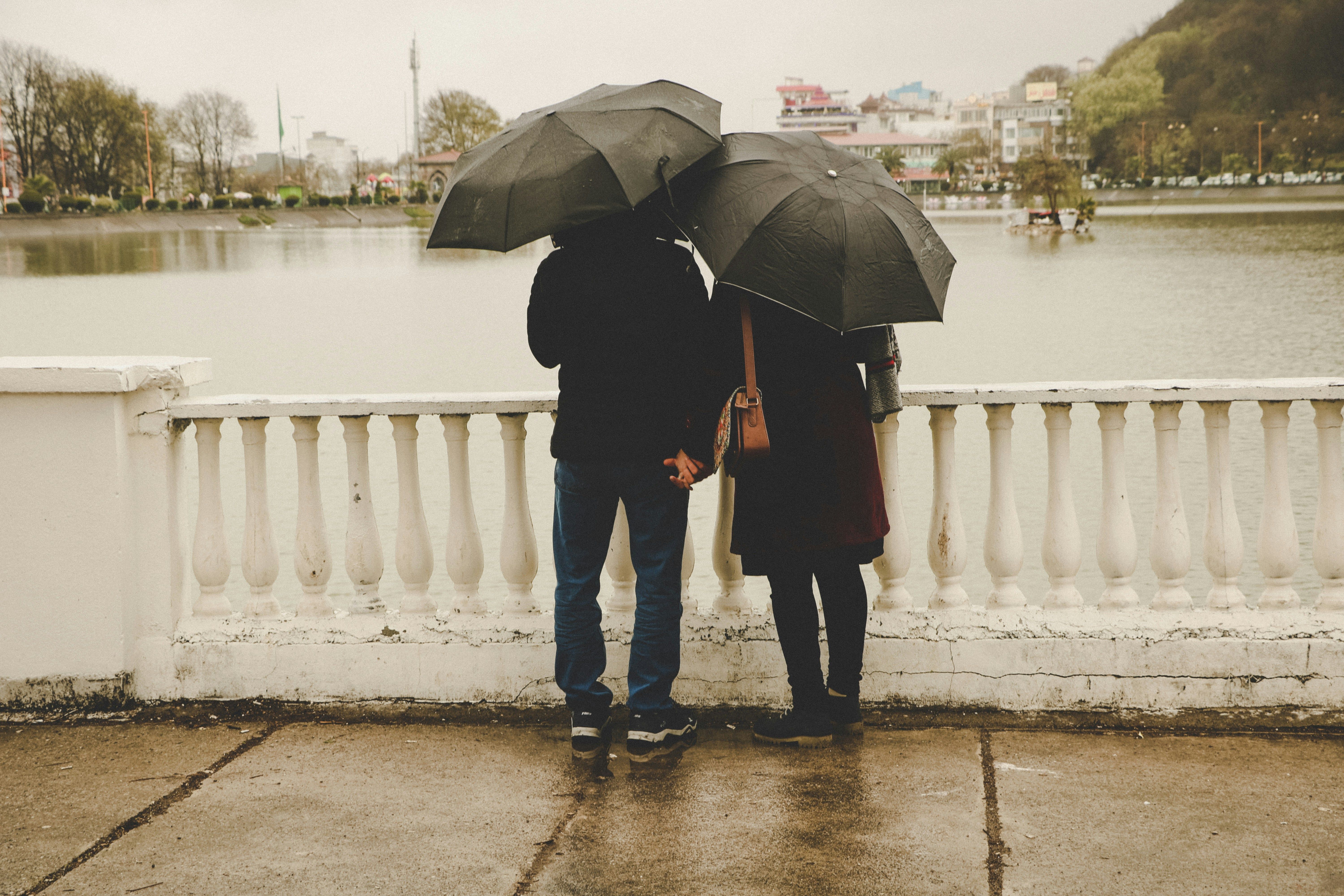Couple holding hands by a lake.