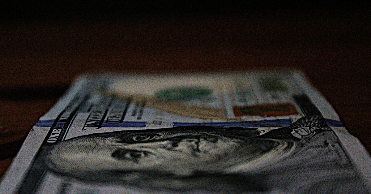 $100 bill laying on a table.