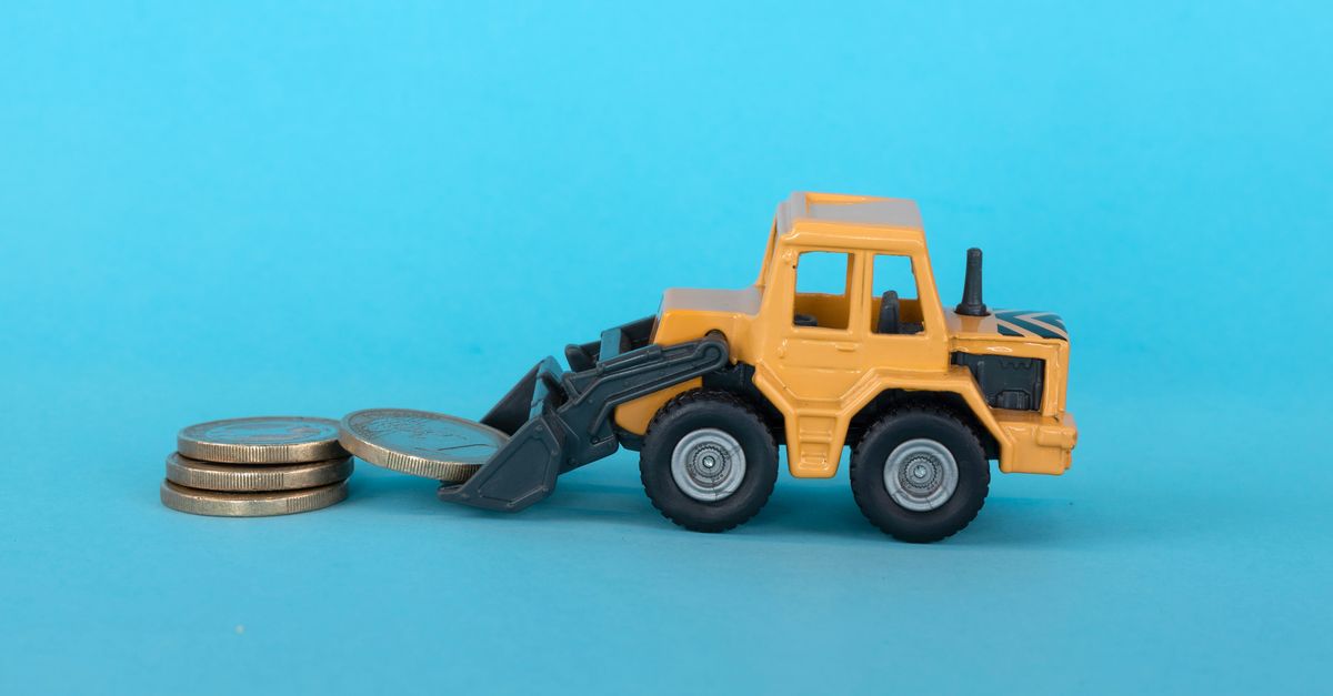 A toy excavation truck picking up money.