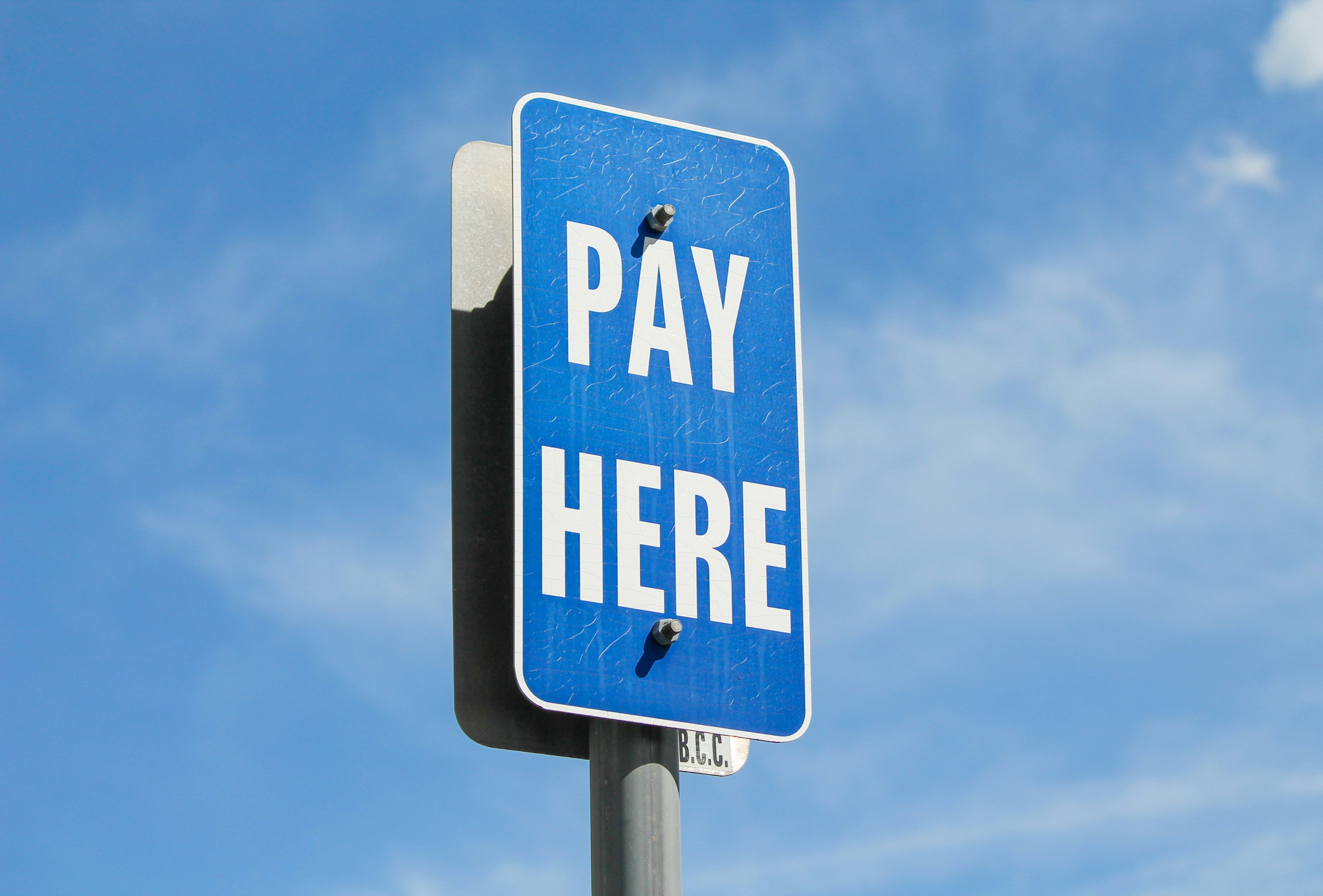 Blue sign saying "pay here".