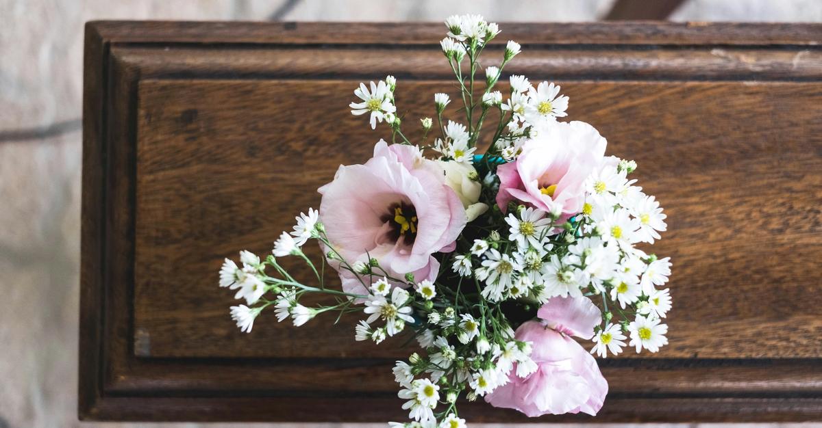Funeral with flowers on the casket by Mayron Oliveira.