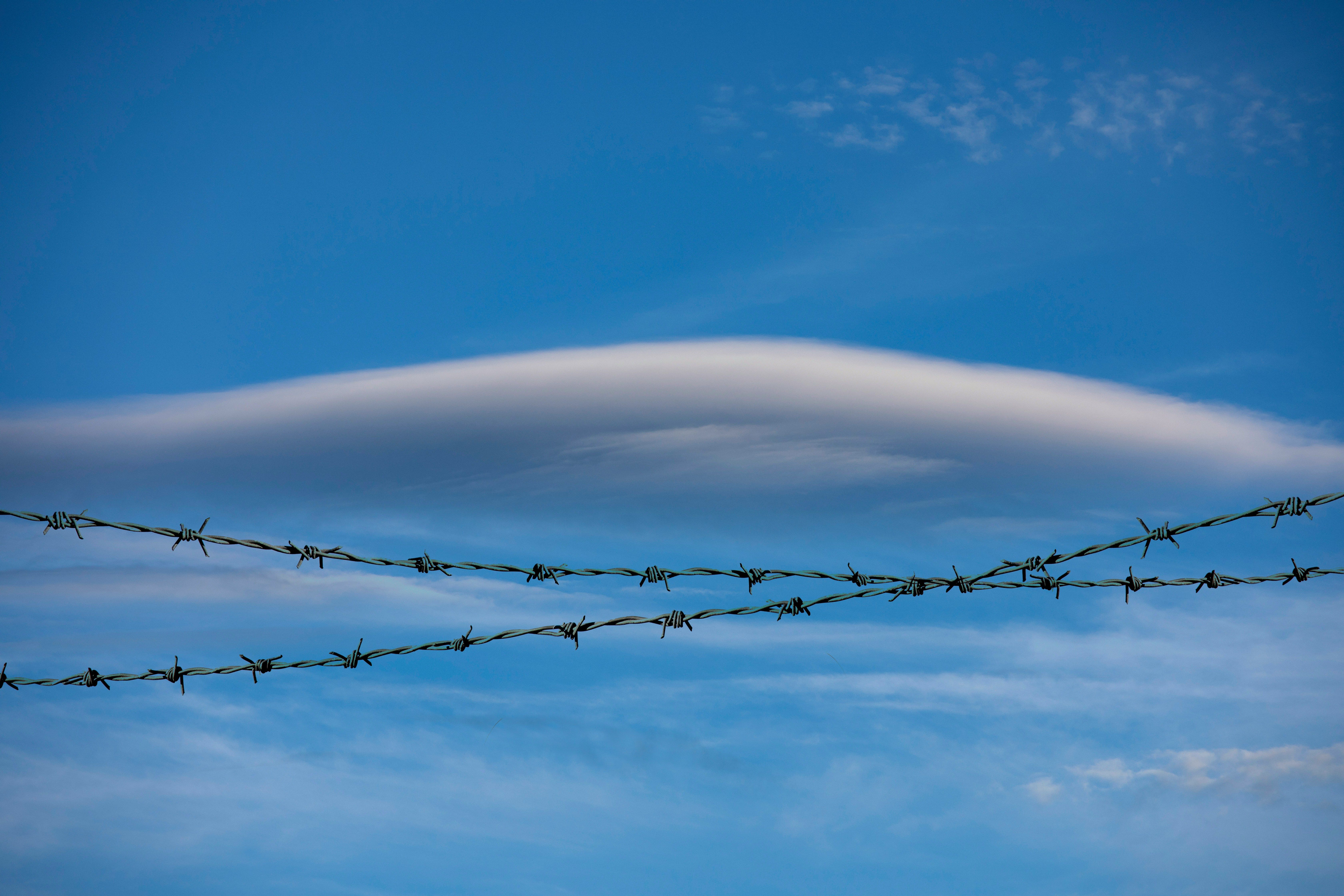 Wired fence with a backdrop of the sky by louise whelan.