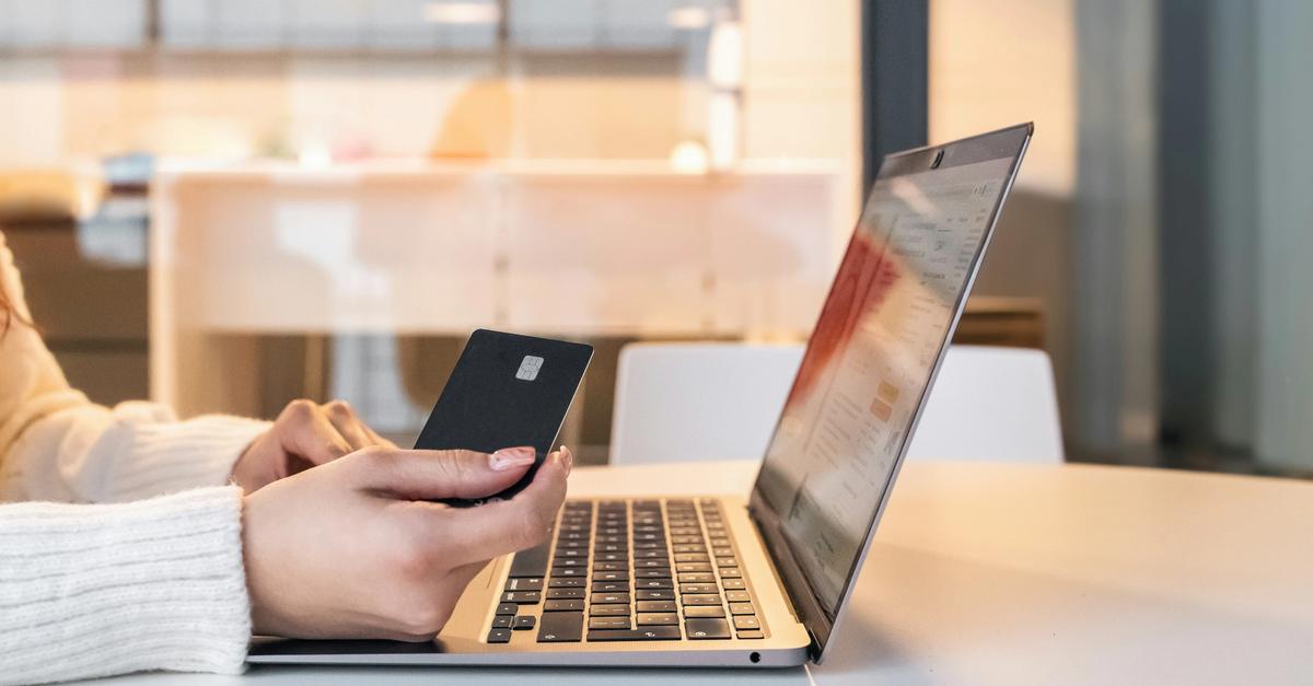Women purchasing with/using a credit card on a laptop.