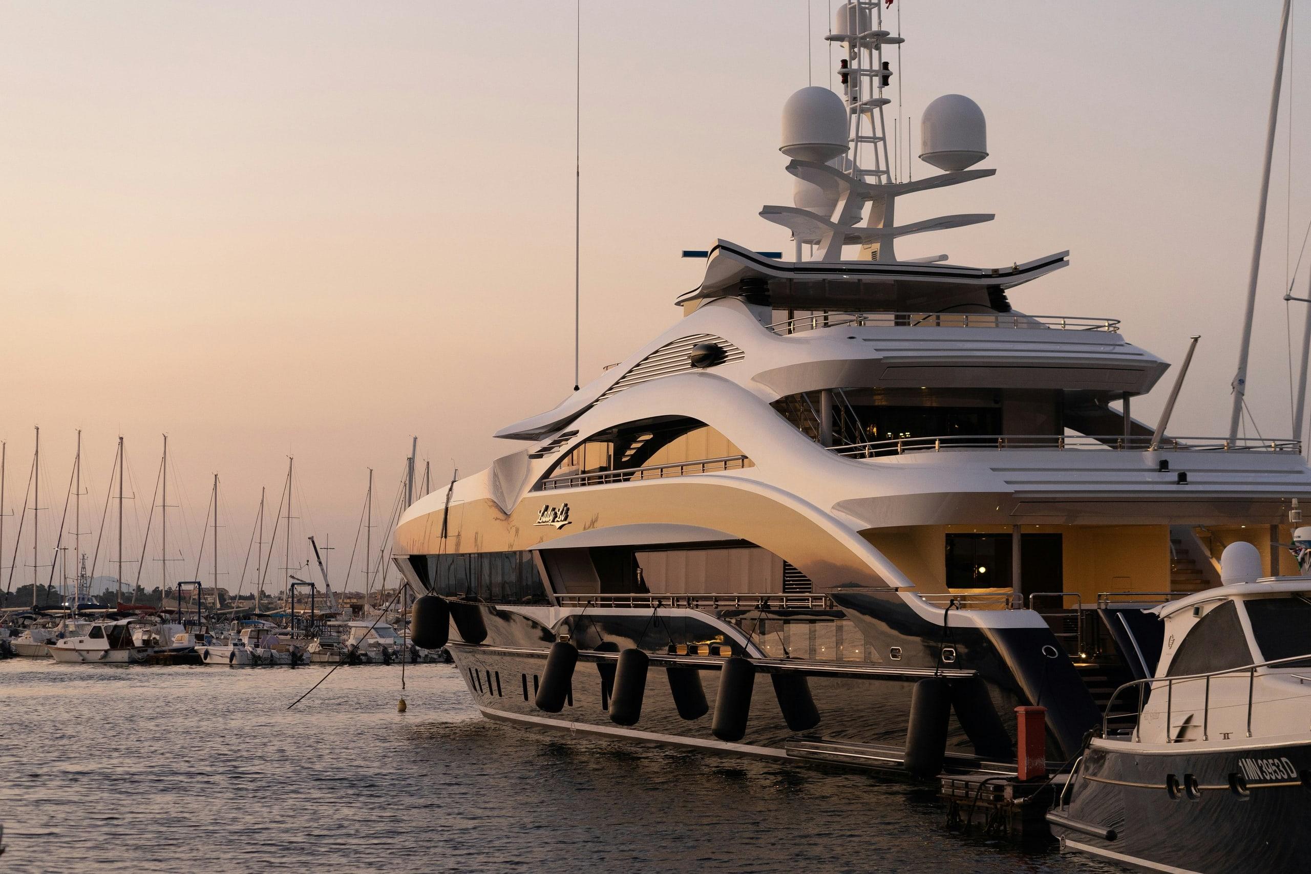 A superyacht moored in a marina at dusk