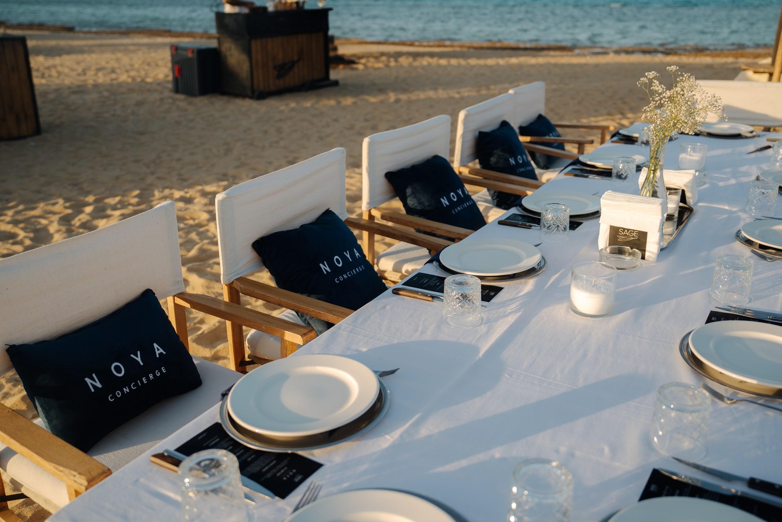 Place settings with NOYA cushions facing the sea