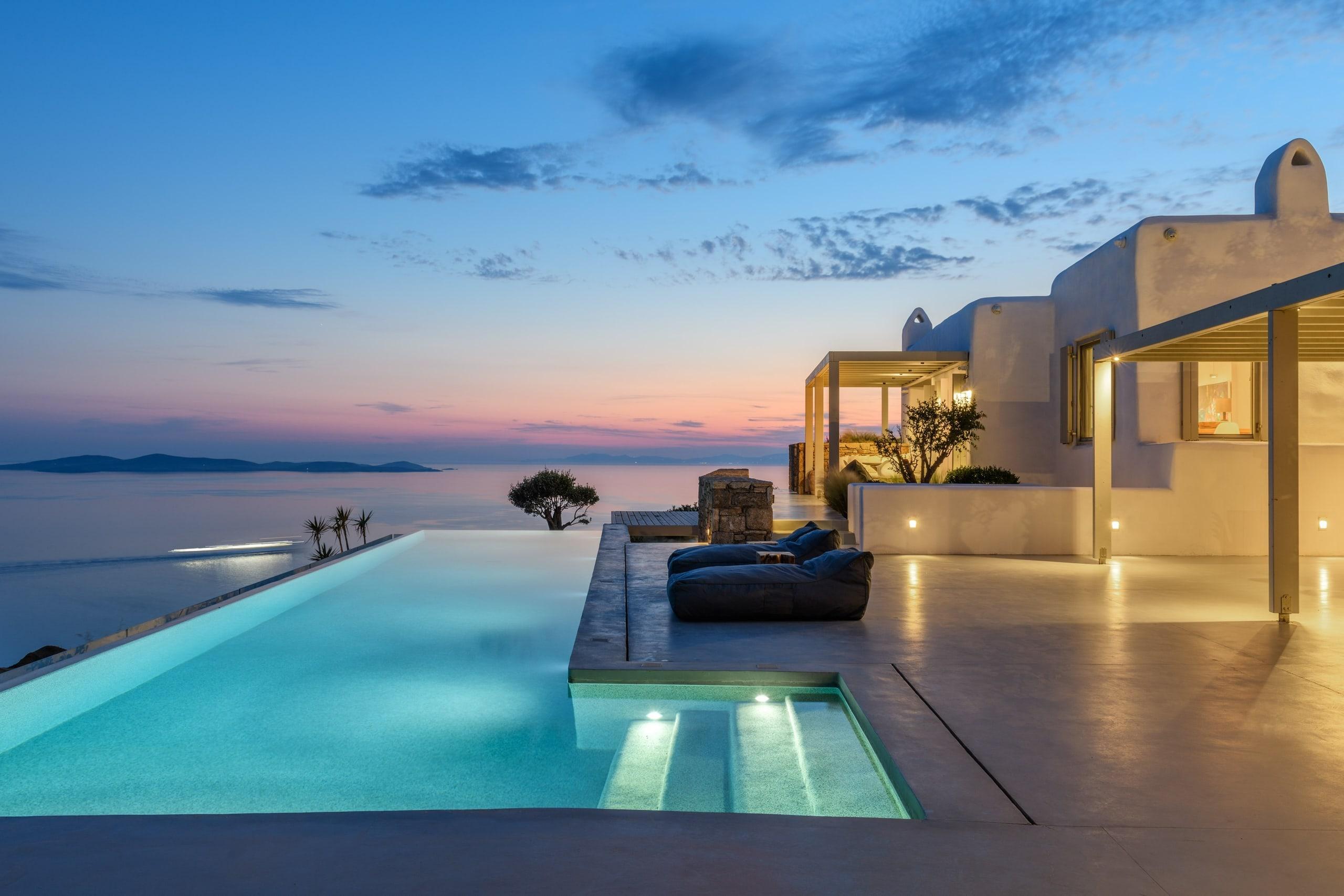A whitewashed villa and infinity pool at blue hour in Mykonos